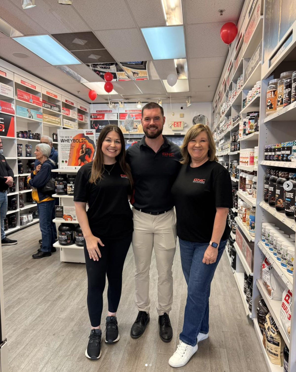 GNC store staff wearing branded uniforms