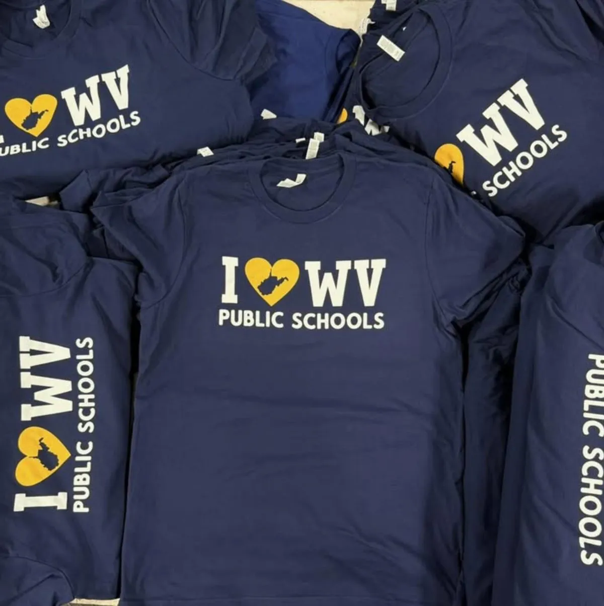 Stack of fundraiser shirts printed for a school