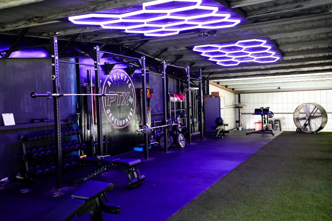 PTX Athletic Development training room with racks, turf and lights