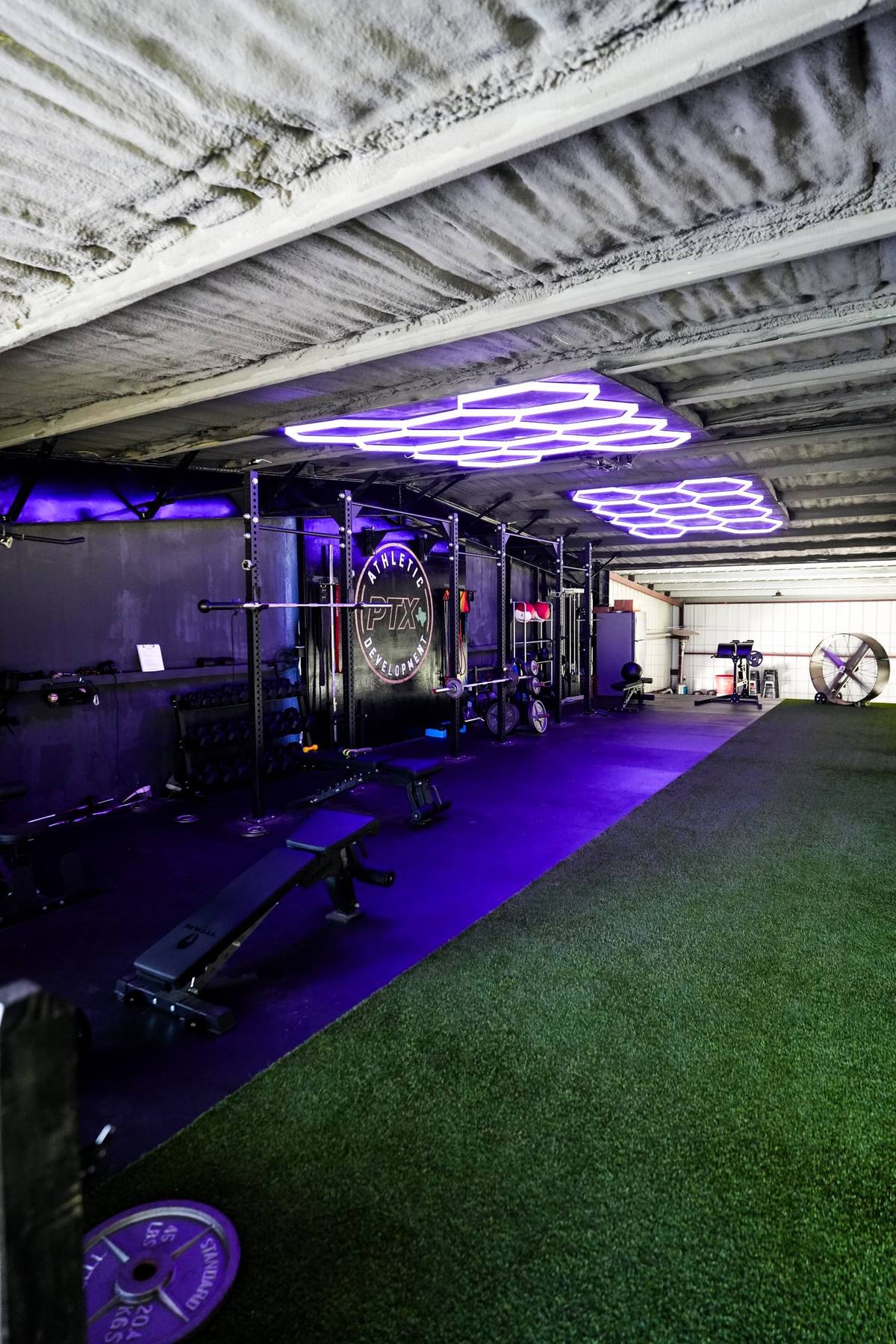 PTX Athletic Development weight room under hexagon lights
