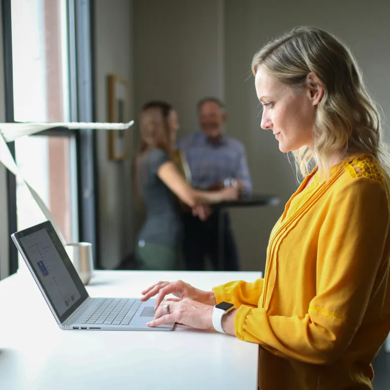 Woman working on a laptop at a desk.