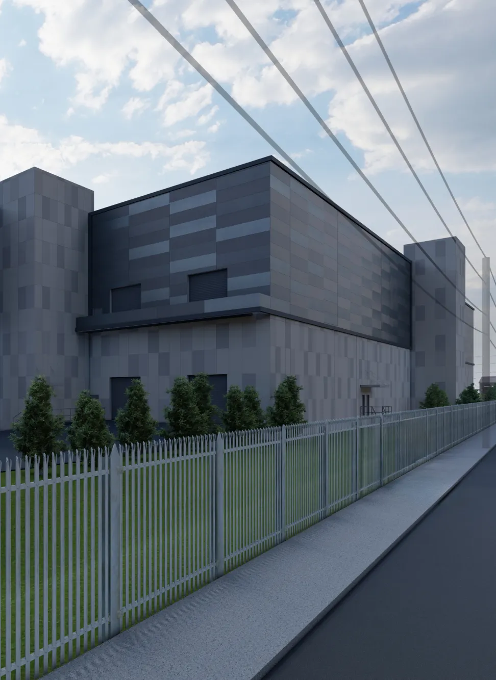 Modern industrial building with a gray patterned facade, surrounded by a metal fence and small trees, under a partly cloudy sky with visible power lines above.
