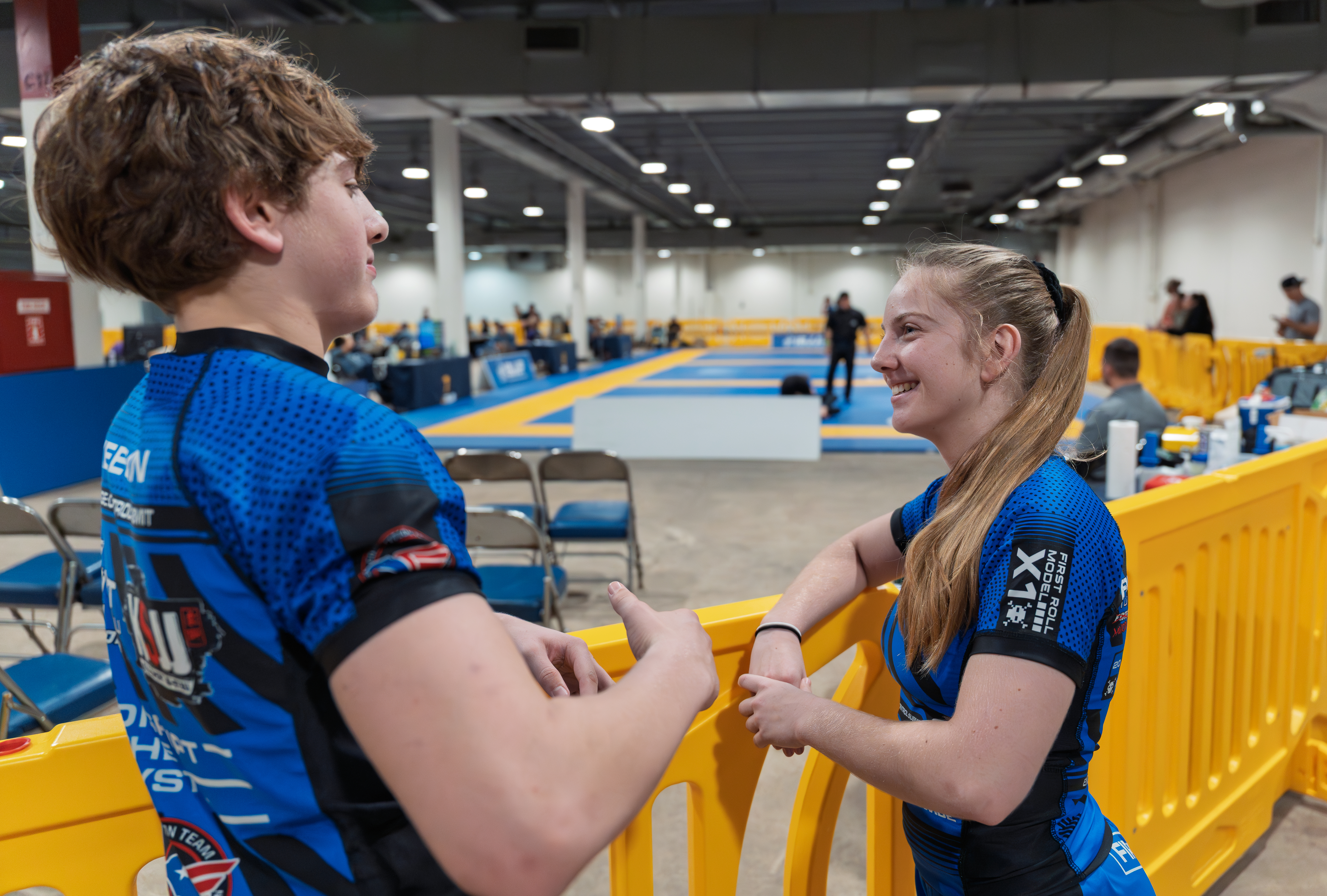 Cadence and Keegan share a light moment beside the competition mats.