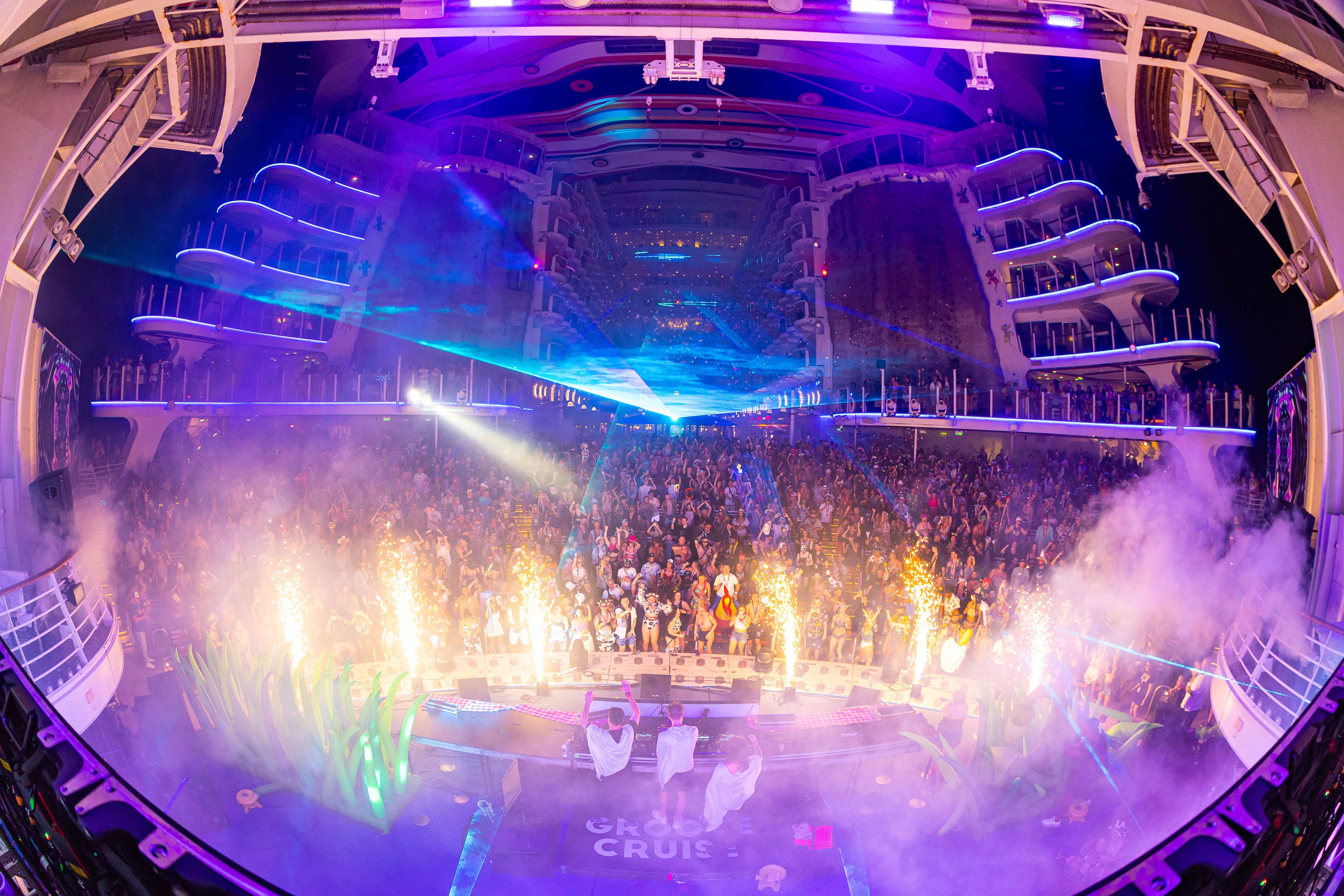Groove Cruise crowd on the Allure of the Seas Aqua Theater deck with lasers and sparklers
