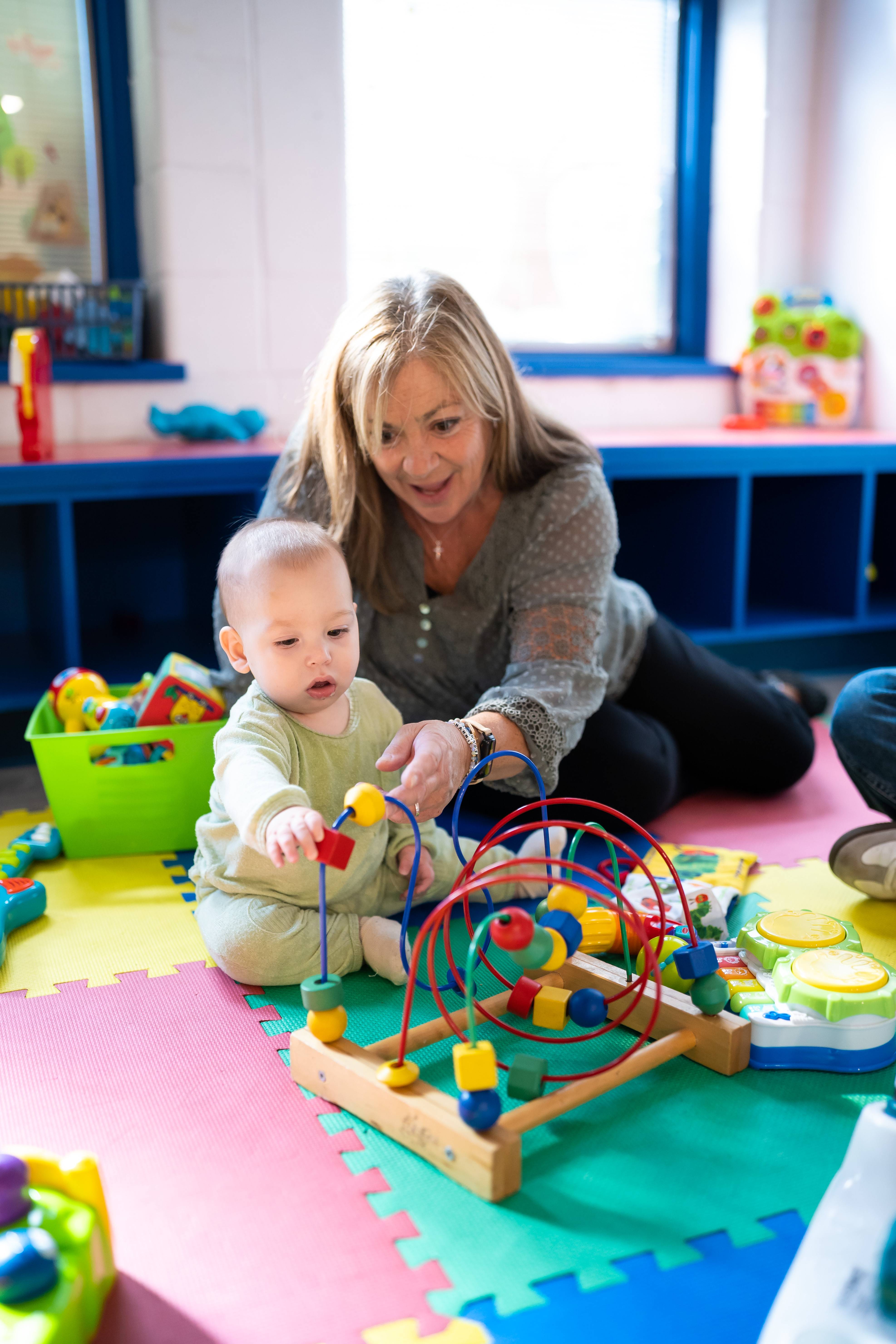 Caregiver playing with a baby in the Baby Room