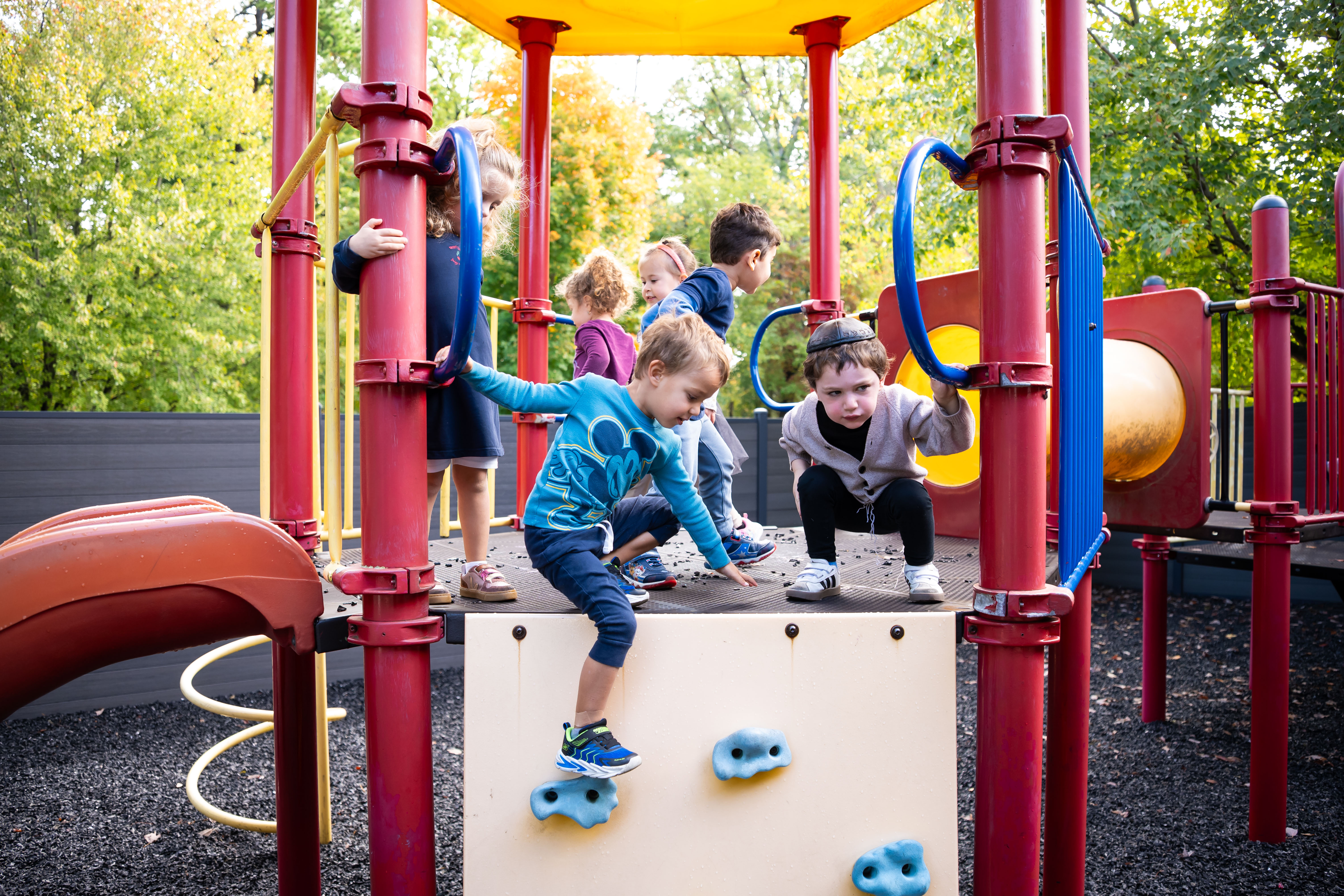 Children climbing on the outdoor play structure