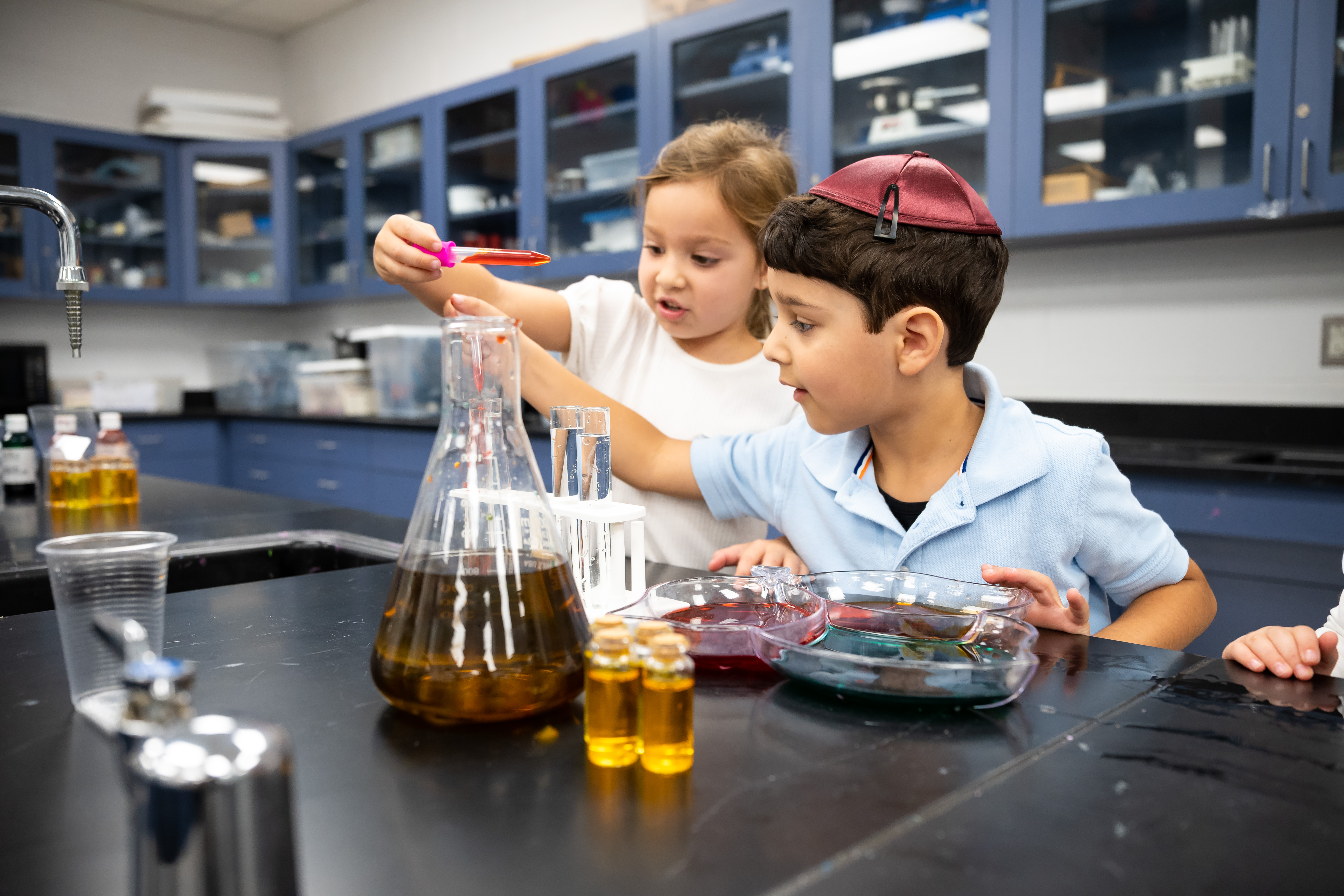 Children pouring colored water during a science experiment