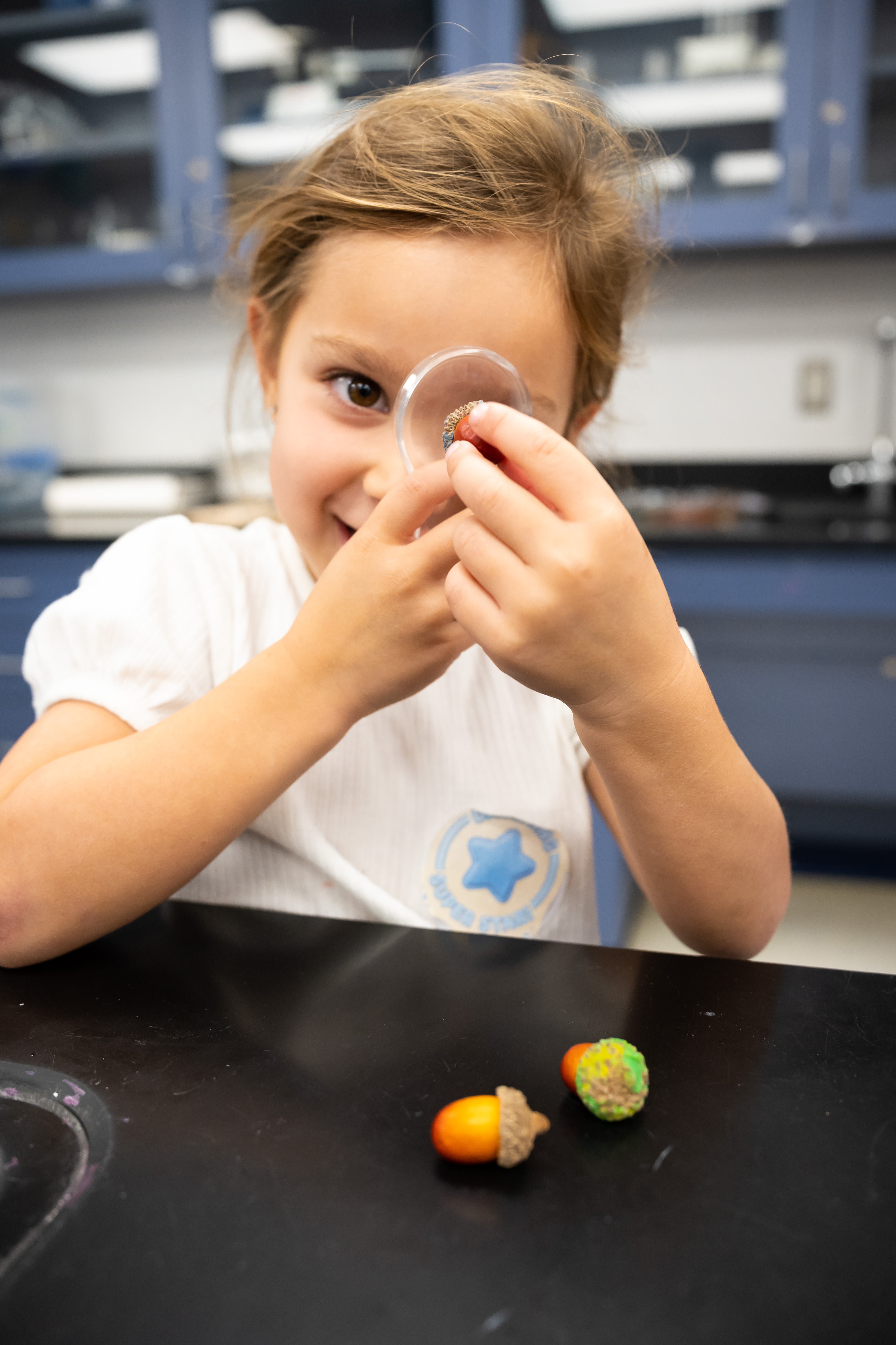 Student looking through a magnifying glass in the science lab