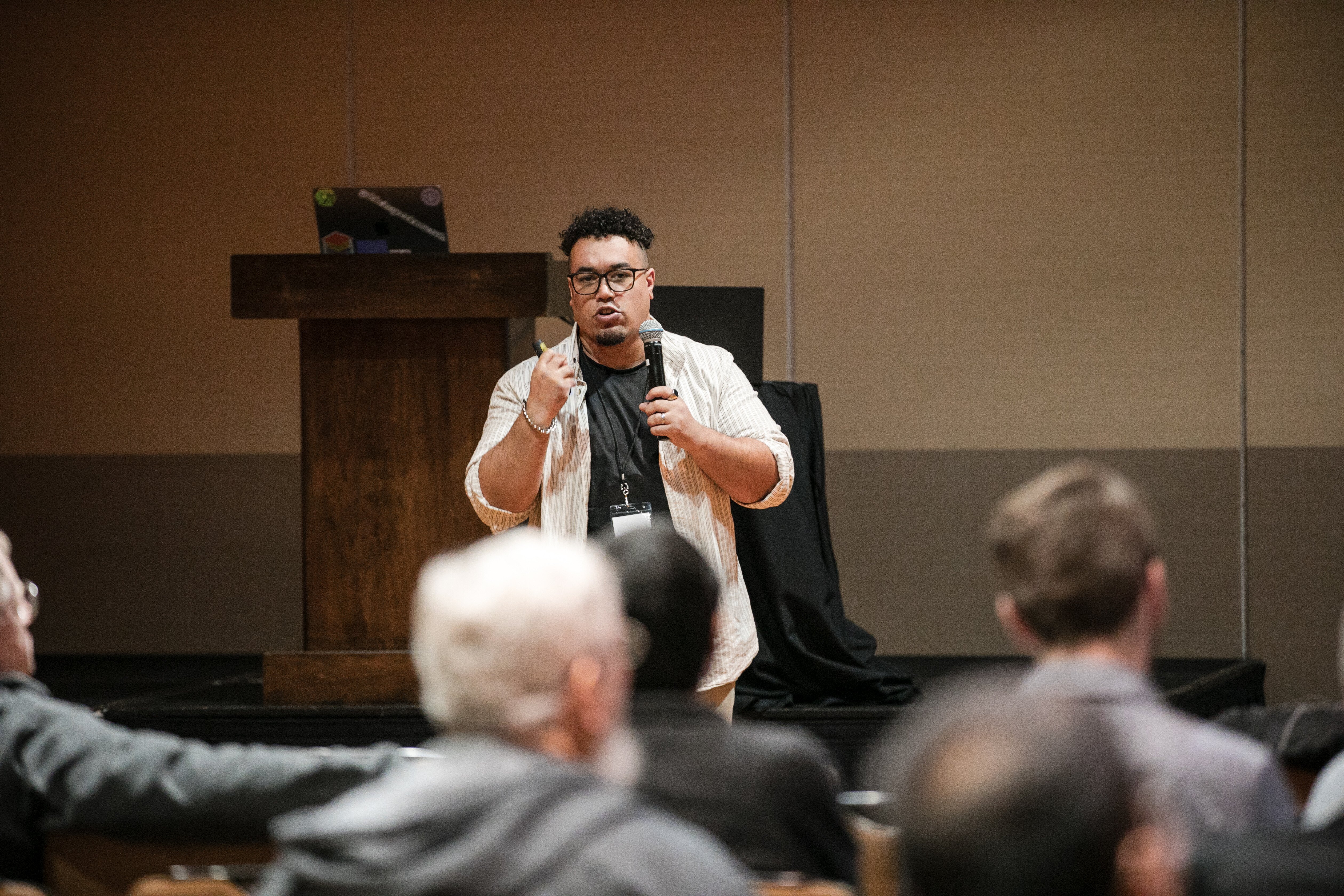 Mark Freeman speaking into a microphone at a live event