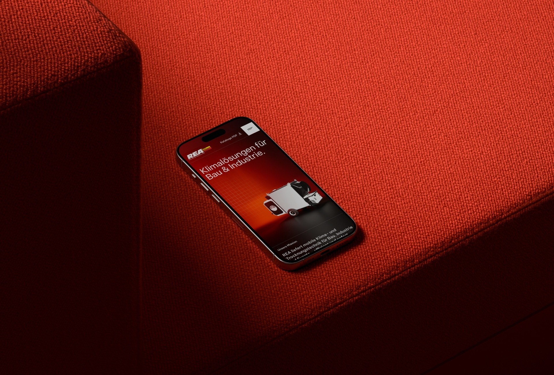 Smartphone mit der mobilen REA-Website auf rotem Polster