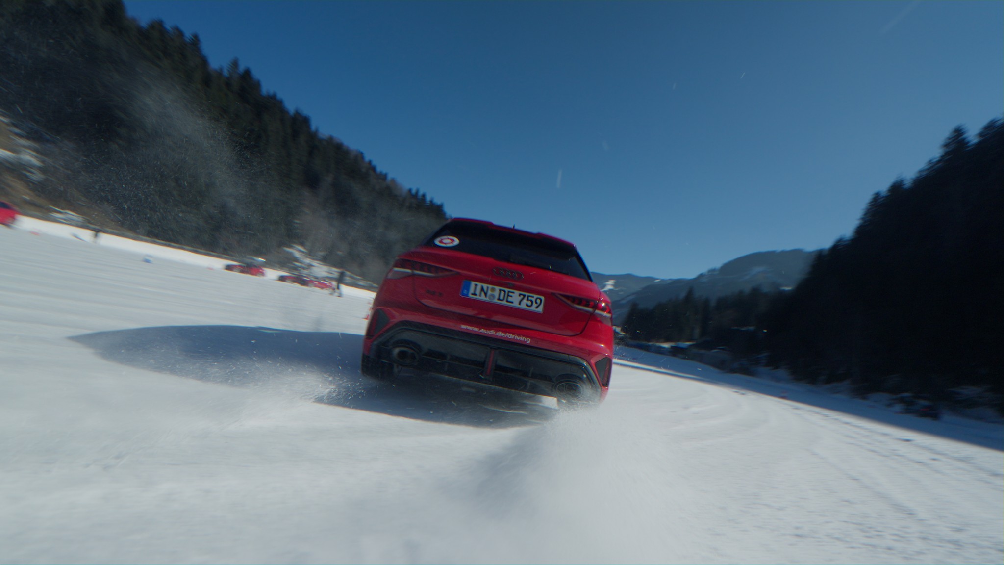 Roter Audi driftet über eine verschneite Strecke