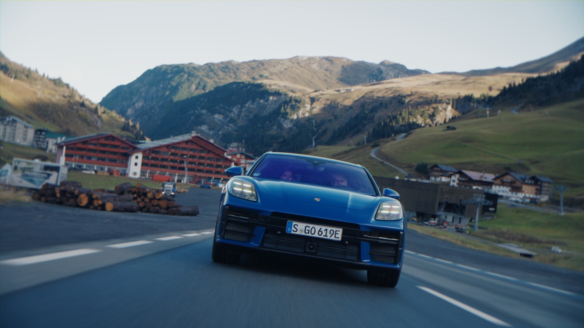Blauer Porsche fährt durch ein Bergdorf
