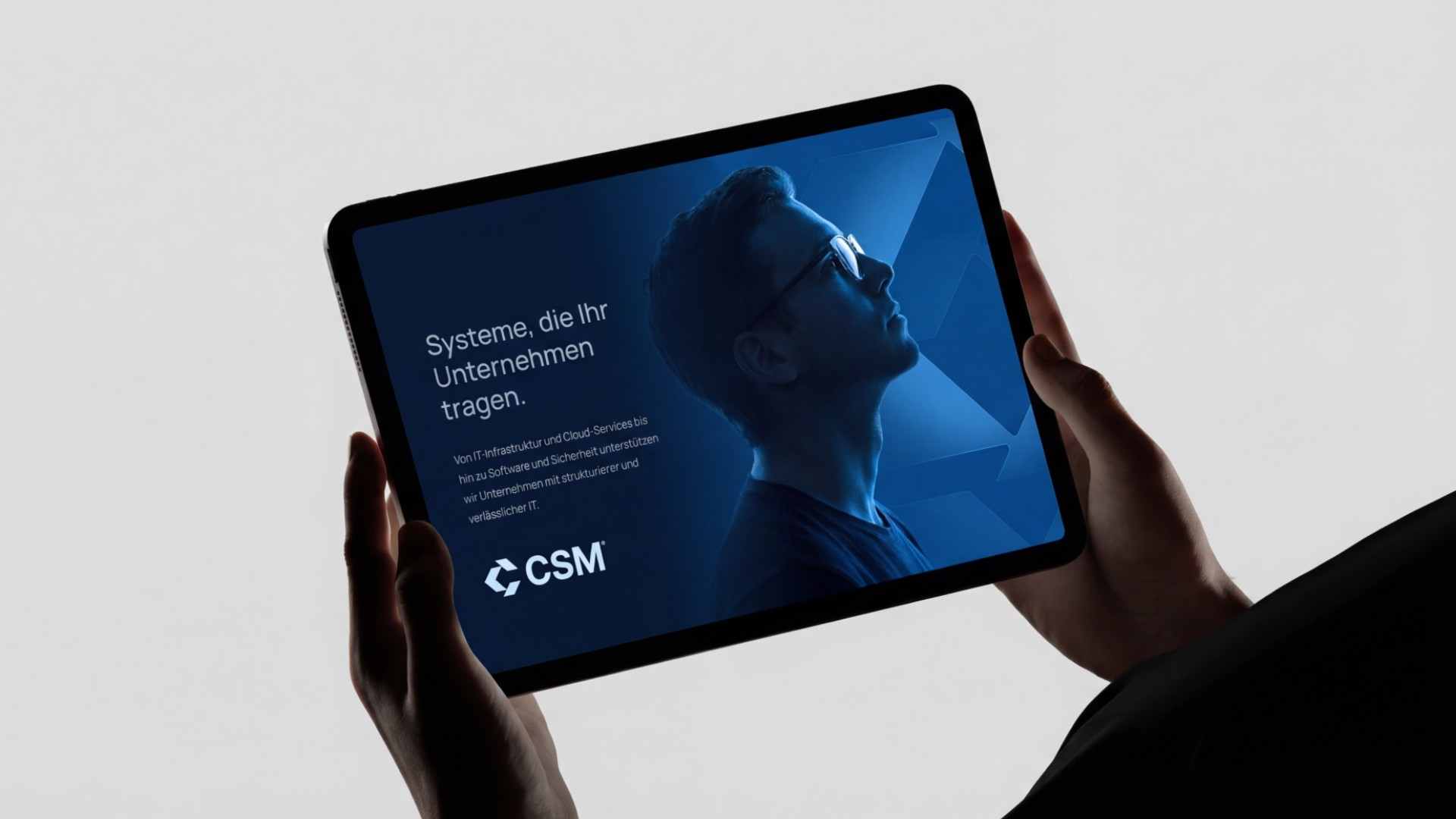 Hände halten Tablet mit der CSM-Website