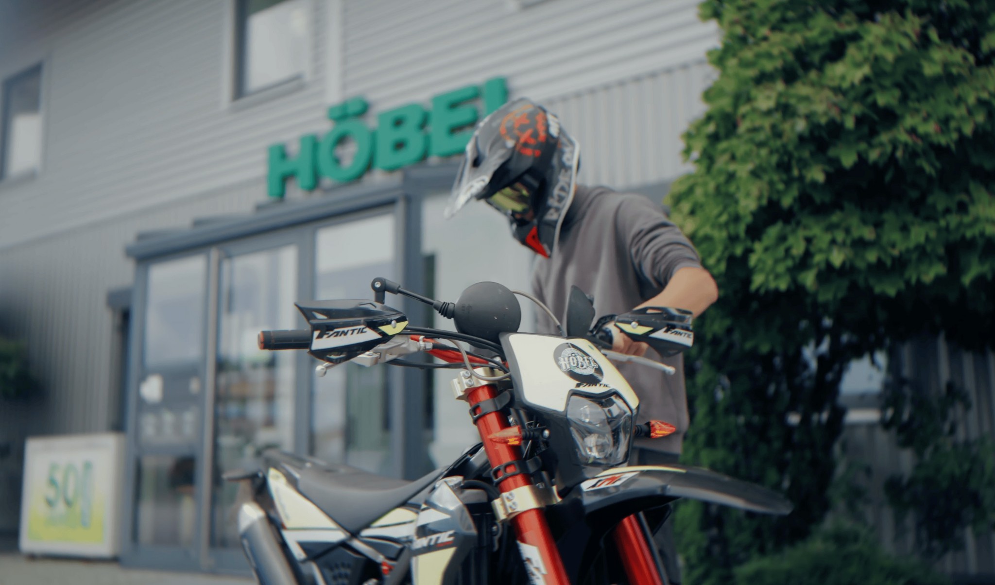 Fahrer auf einem Motorrad vor dem Höbel-Firmengebäude, Szene aus dem Imagefilm