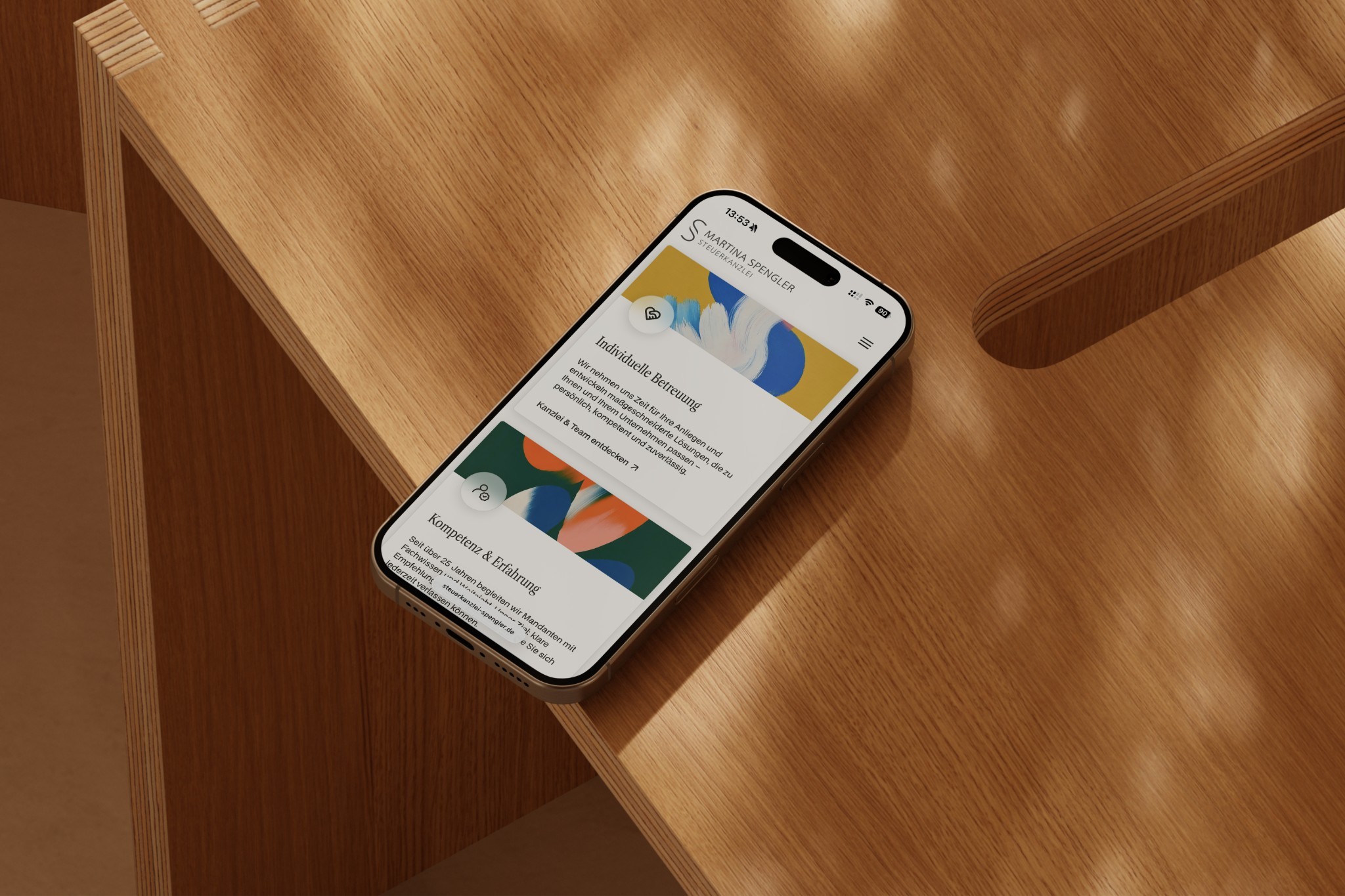 Smartphone mit der Website der Steuerkanzlei Spengler auf Holz