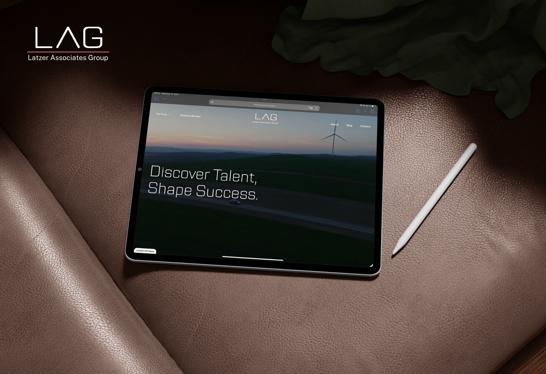 Tablet mit der Website von Latzer Associates auf einem Ledersessel