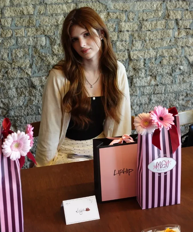 A creator with flower-decorated gift bags at an MGN Society gathering