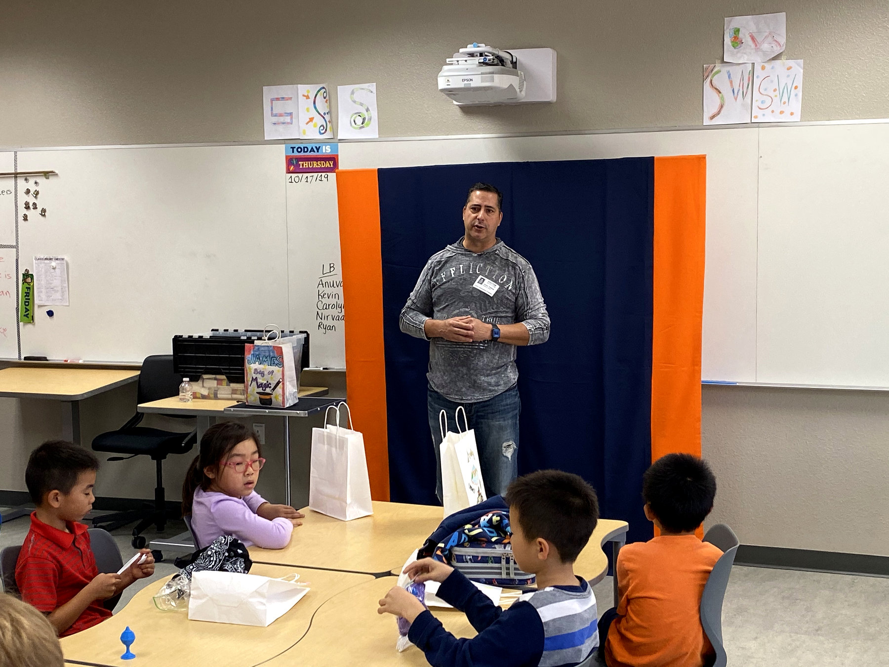 JamesZini instructing students practicing magic in a classroom
