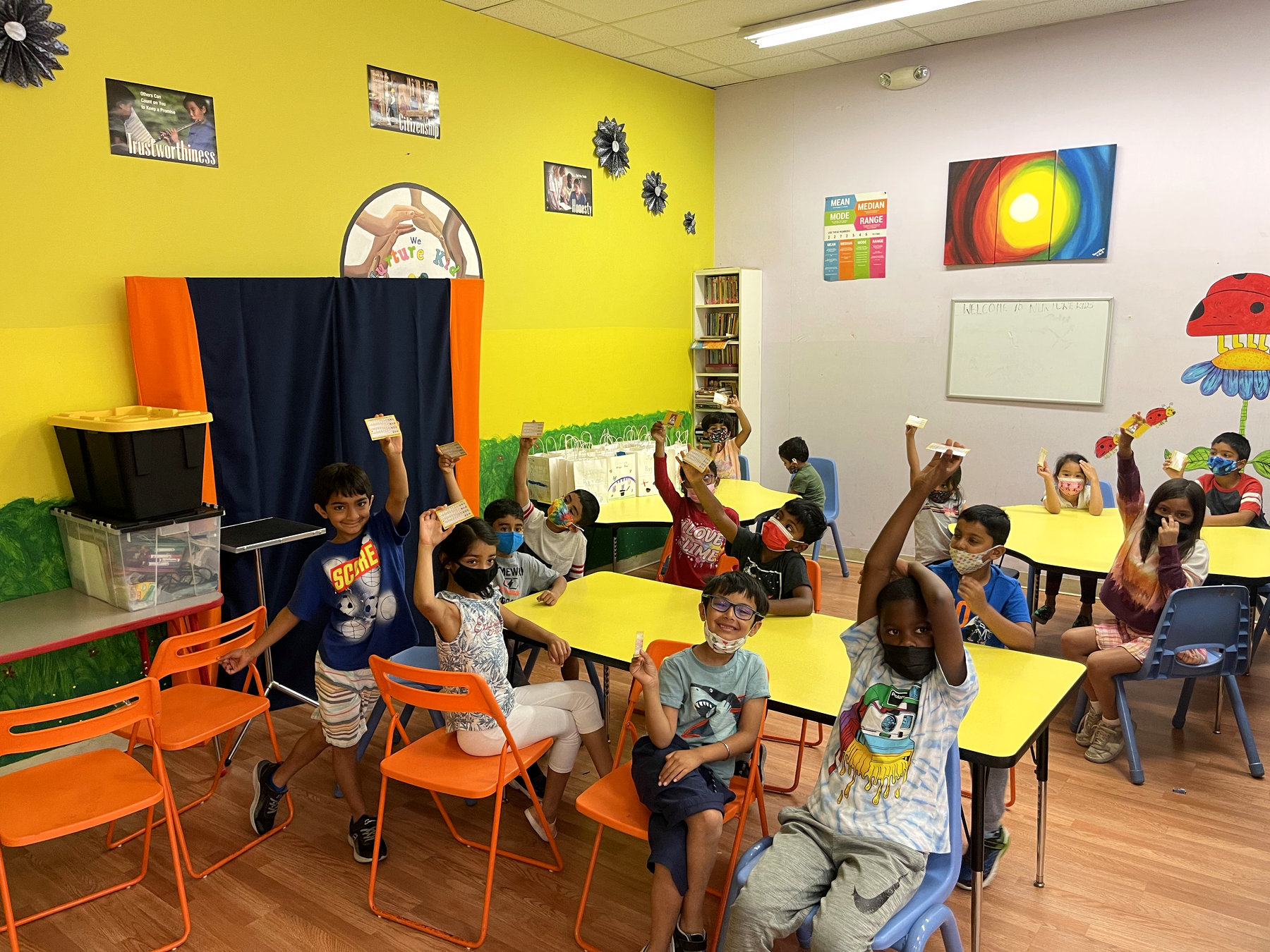 Young students eagerly raising their hands in a hands-on magic class