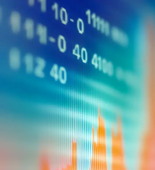 Blurred close-up of a digital screen displaying financial data with numbers and an orange line graph.
