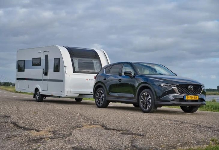 Auto met caravan op een Nederlandse dijkweg