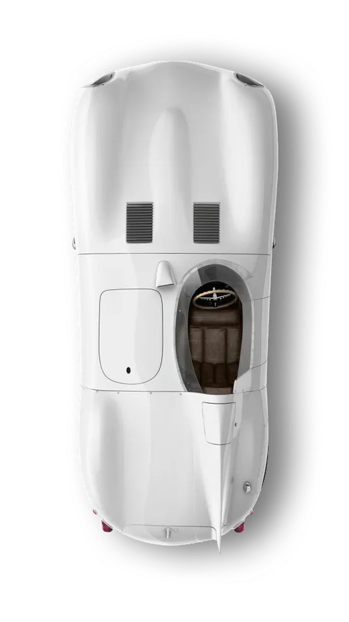Top view of a classic white race car with a single brown leather seat and steering wheel visible through an open cockpit.