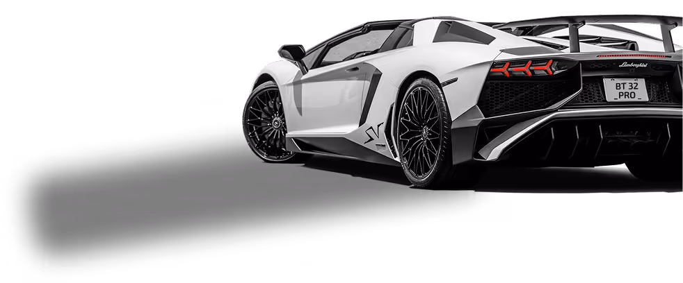 White Lamborghini Aventador SV sports car viewed from rear side with distinctive angular design and black alloy wheels.