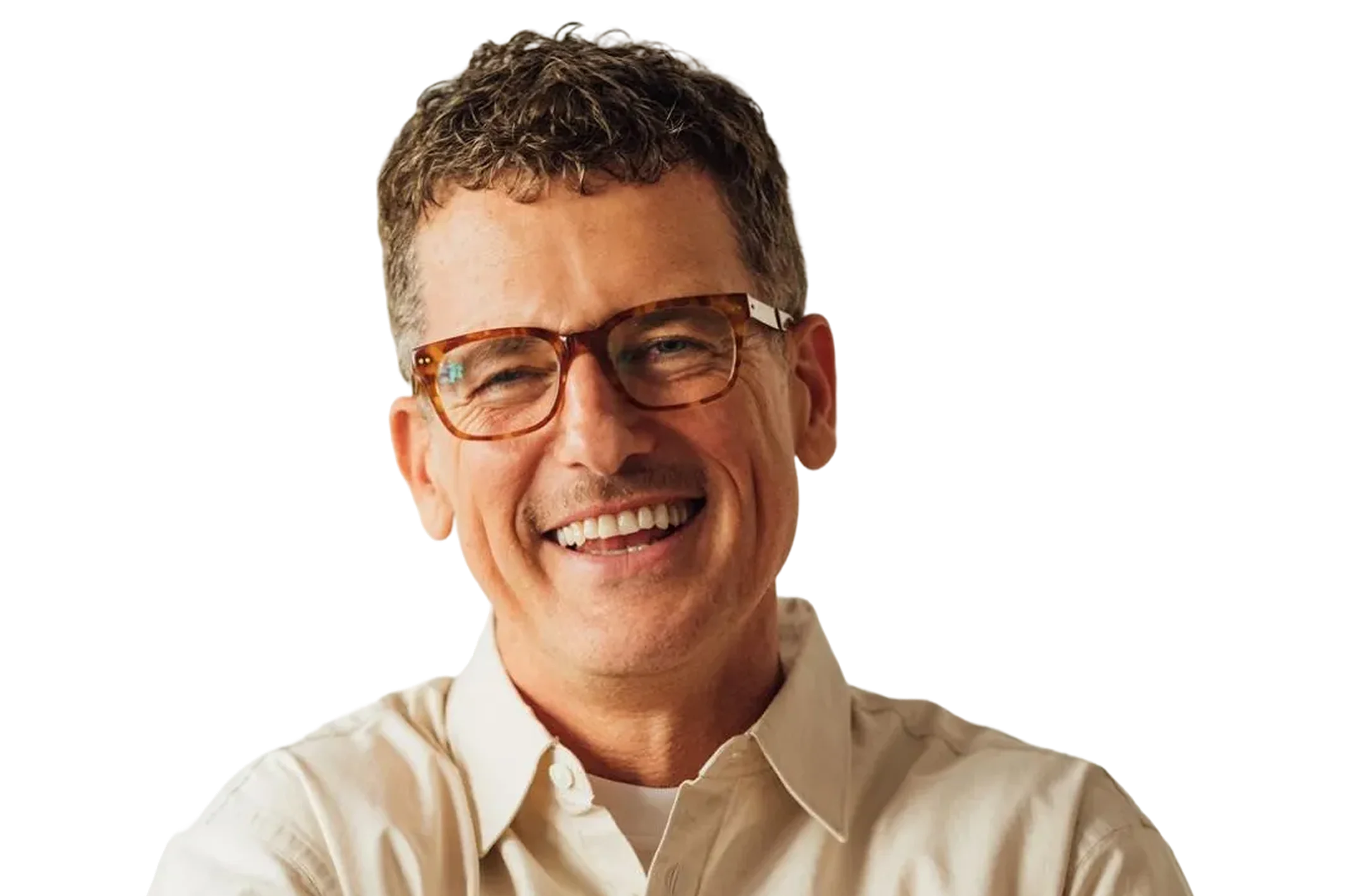 Smiling middle-aged man with short curly hair wearing tortoiseshell glasses and a beige button-up shirt.
