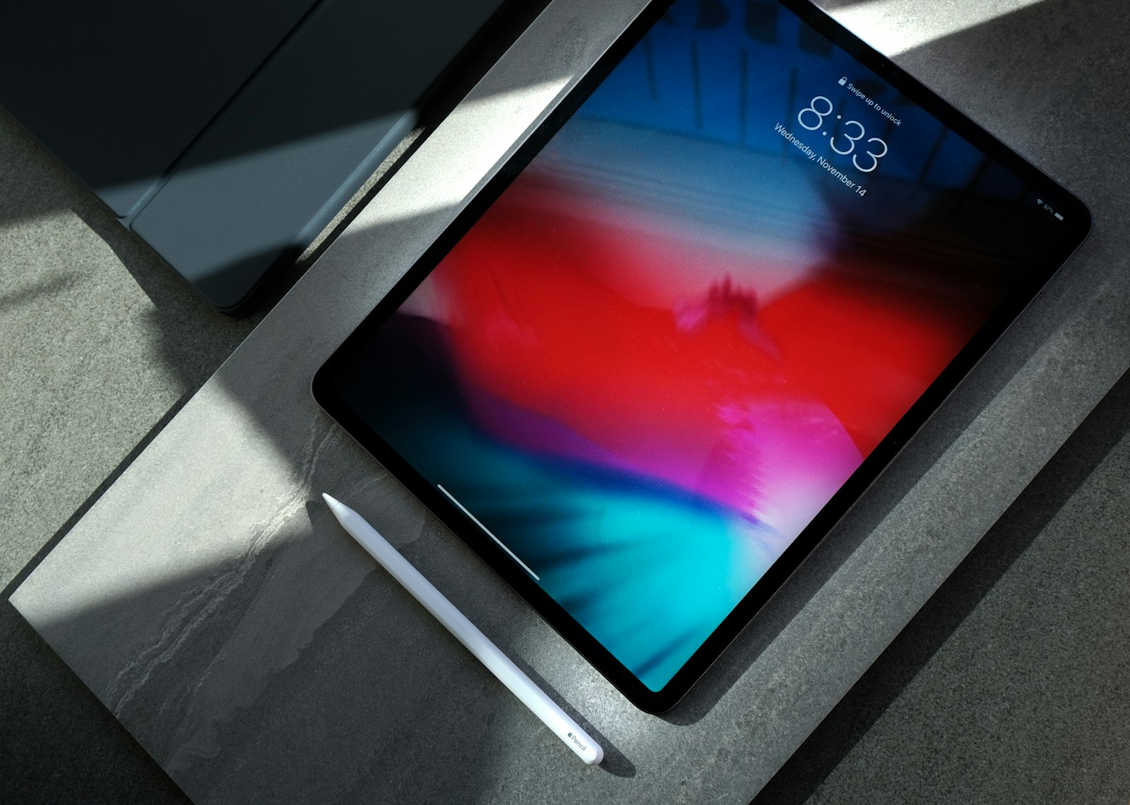 An Apple iPad on a desk with an Apple Pencil