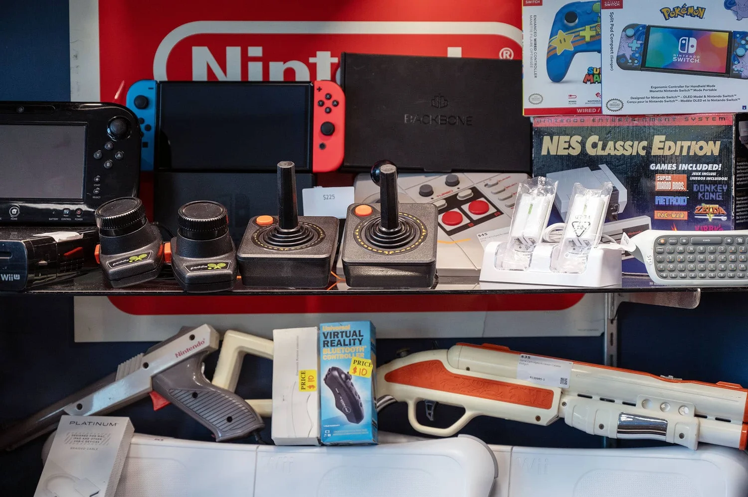 Retro video game consoles and accessories for sale at Looda House Pawn, including Atari joysticks, a Nintendo Switch and an NES Classic Edition