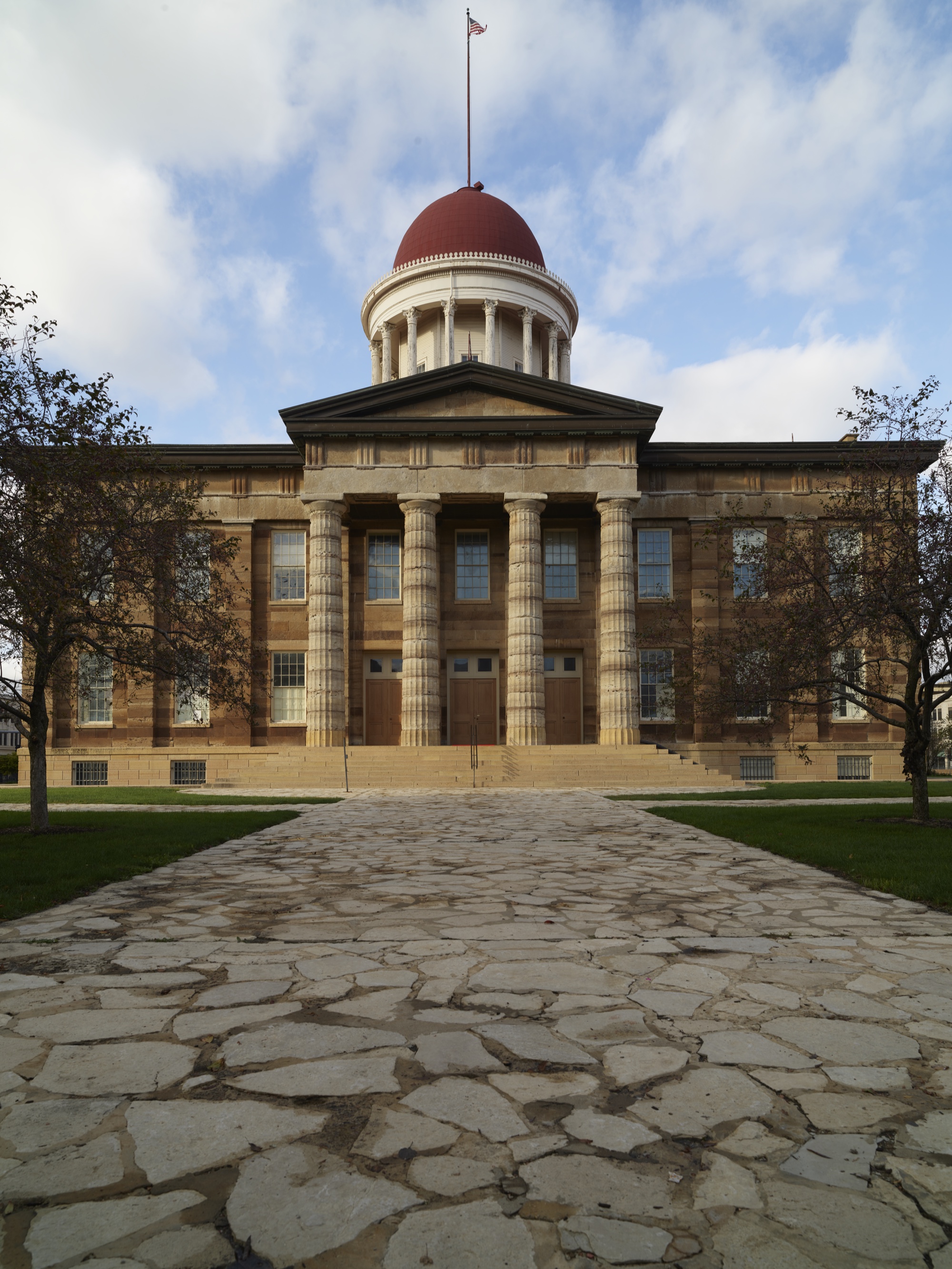The Old State Capitol in Springfield, Illinois, with its red dome and limestone columns, seen from the stone walk in front