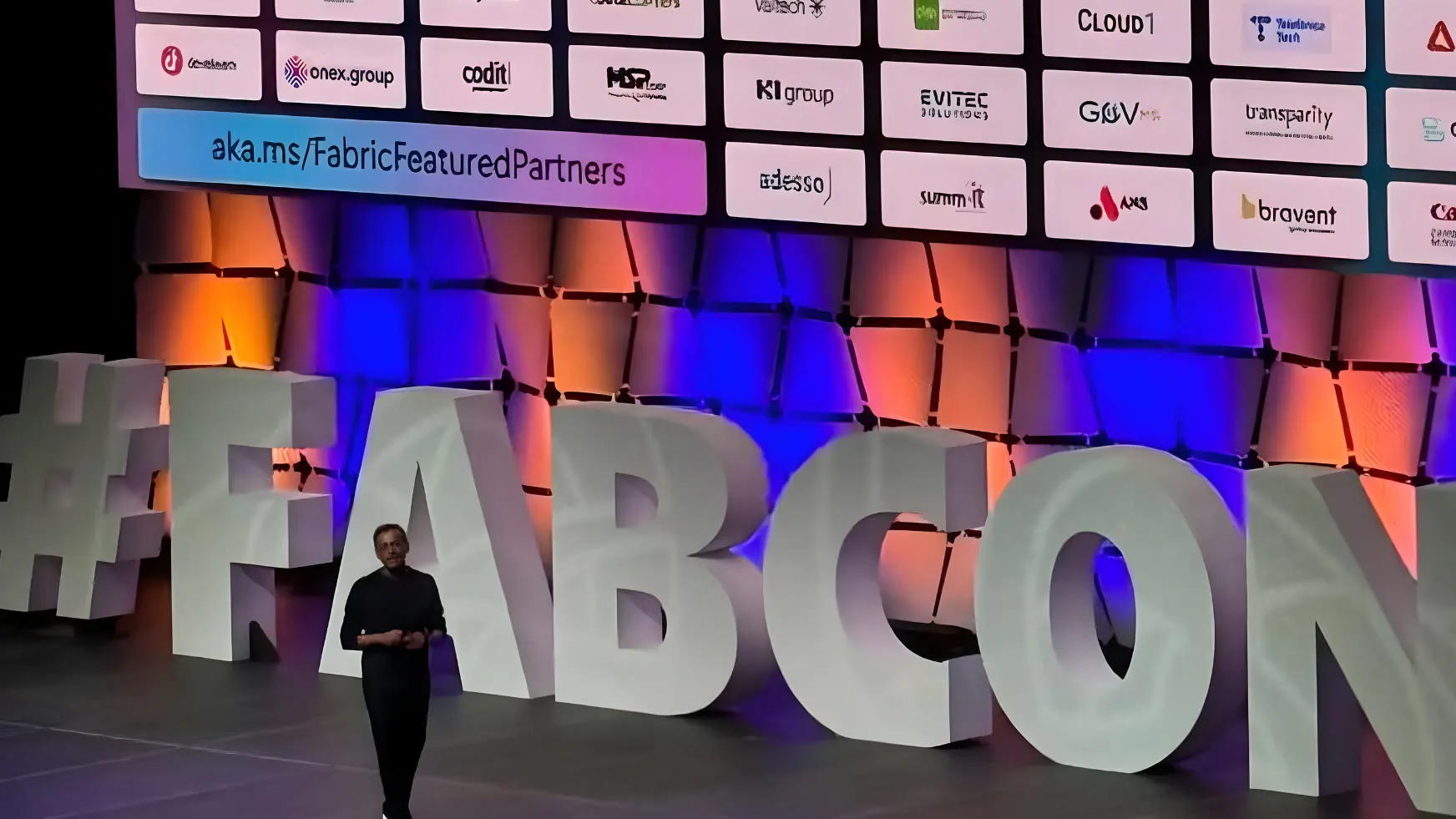 FabCon keynote stage with the Microsoft Fabric Featured Partners wall, including Onex Group – FabCon Poland 2026: Barcelona Update