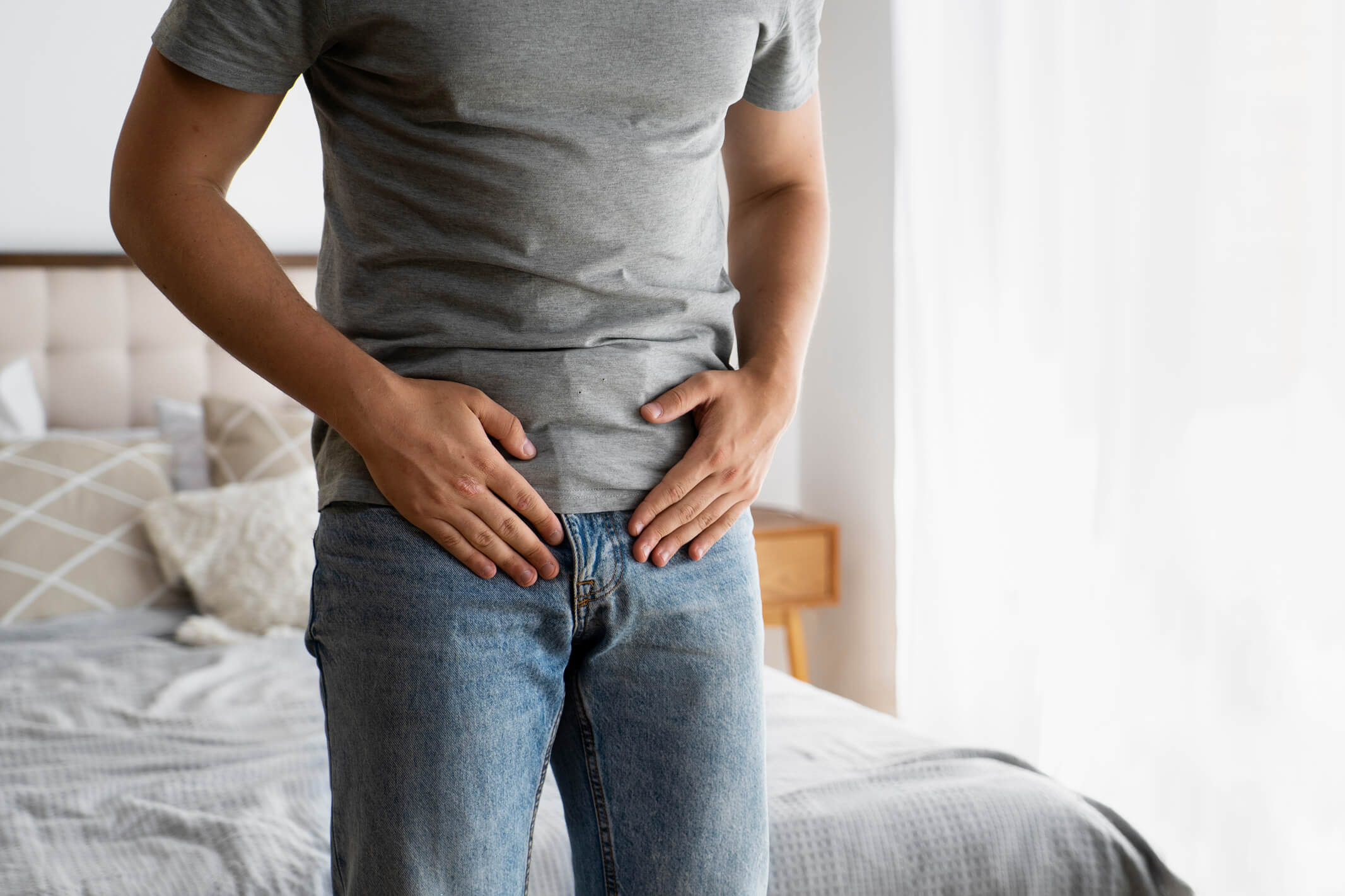 Man holding his lower abdomen and groin in discomfort
