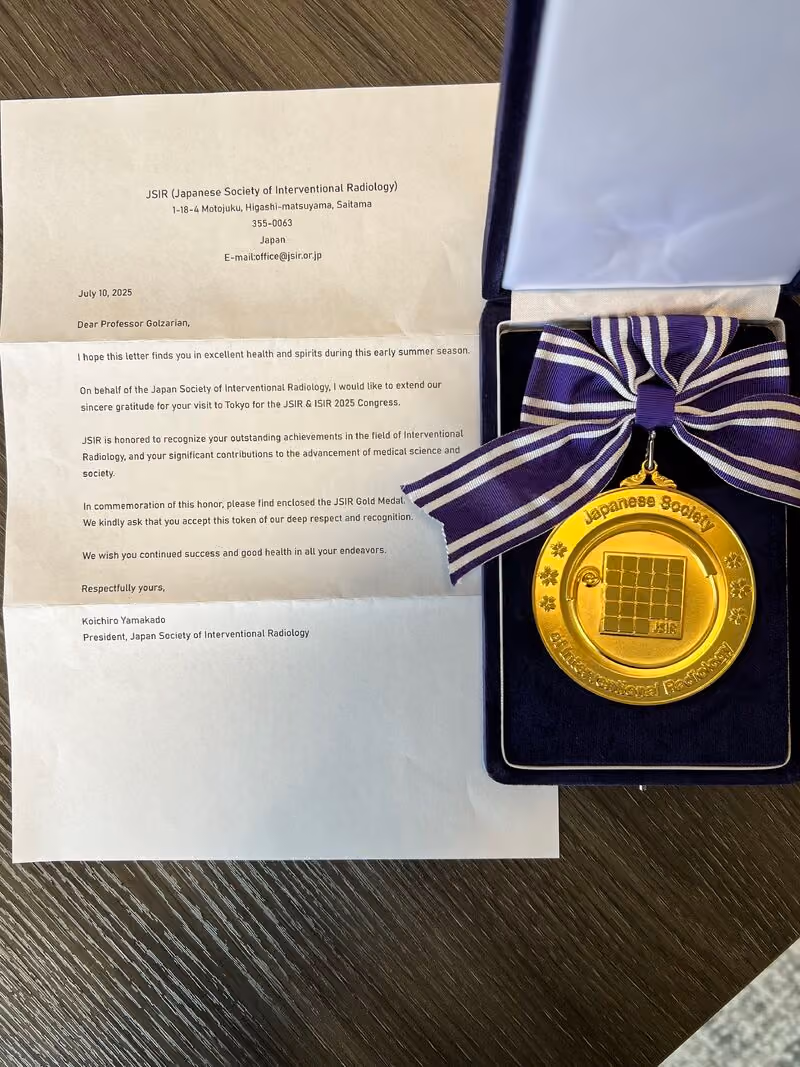 Letter from Japanese Society of Interventional Radiology with JSIR gold medal in a velvet case with purple striped bow.