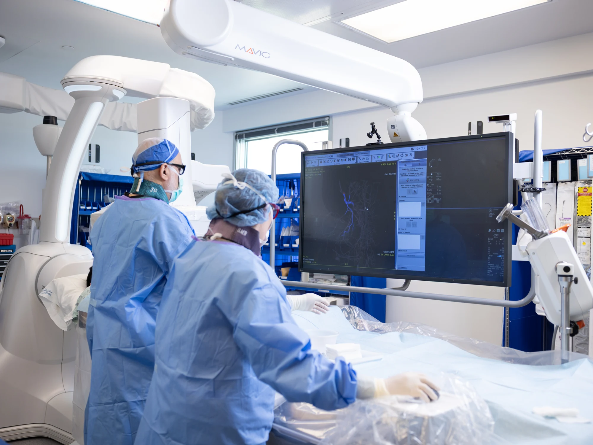 Modern interventional radiology suite with C-arm imaging system and procedure table