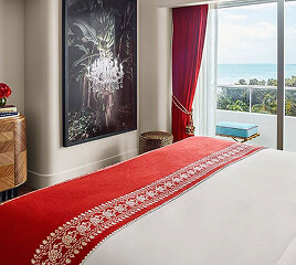 Hotel bedroom with red bedding and framed artwork