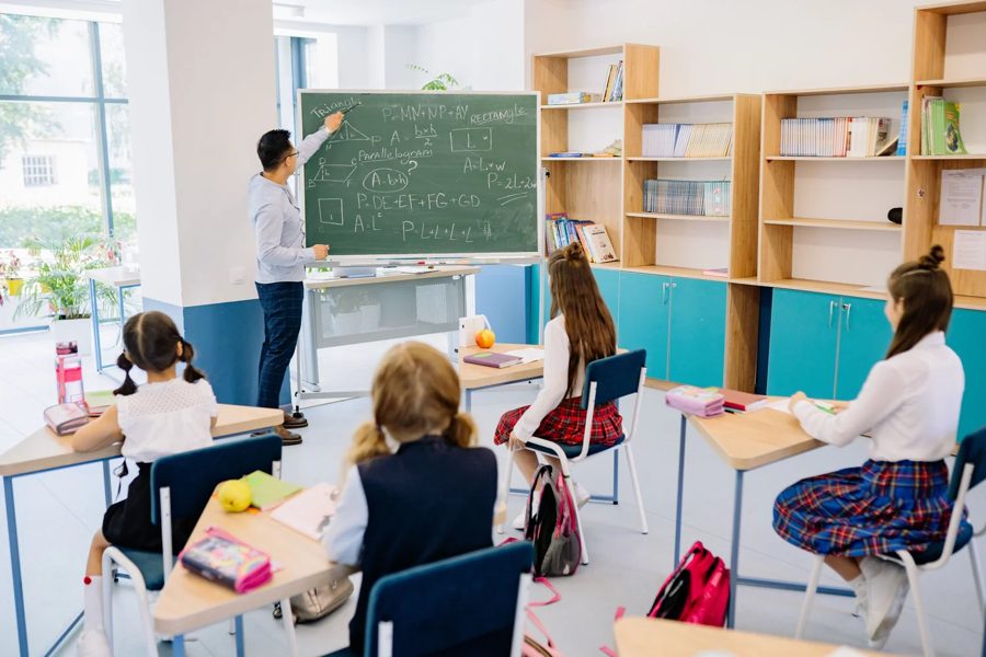 Una maestra en el pizarrón durante una clase de matemáticas