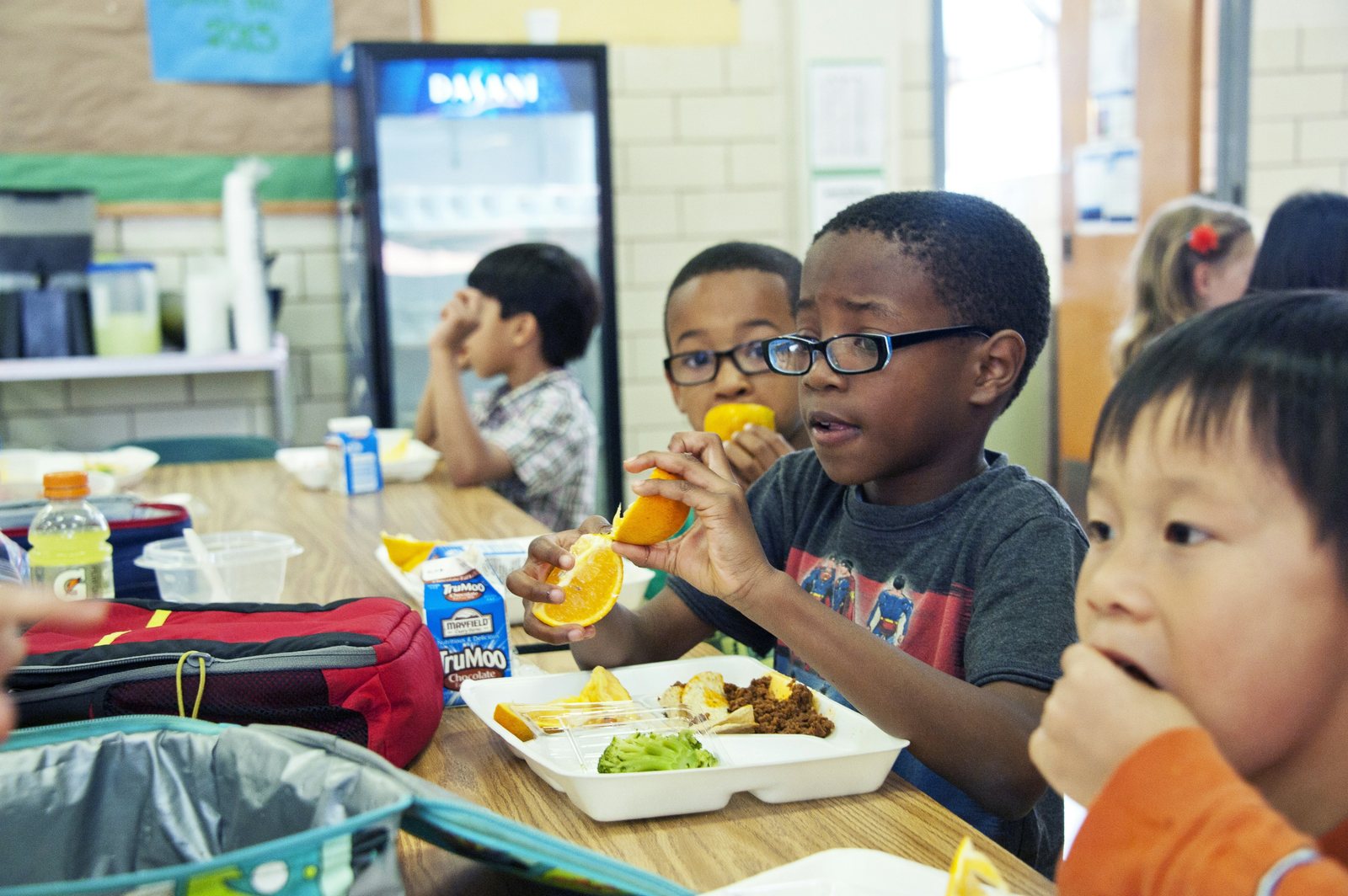 Students eating lunch together at a cafeteria table