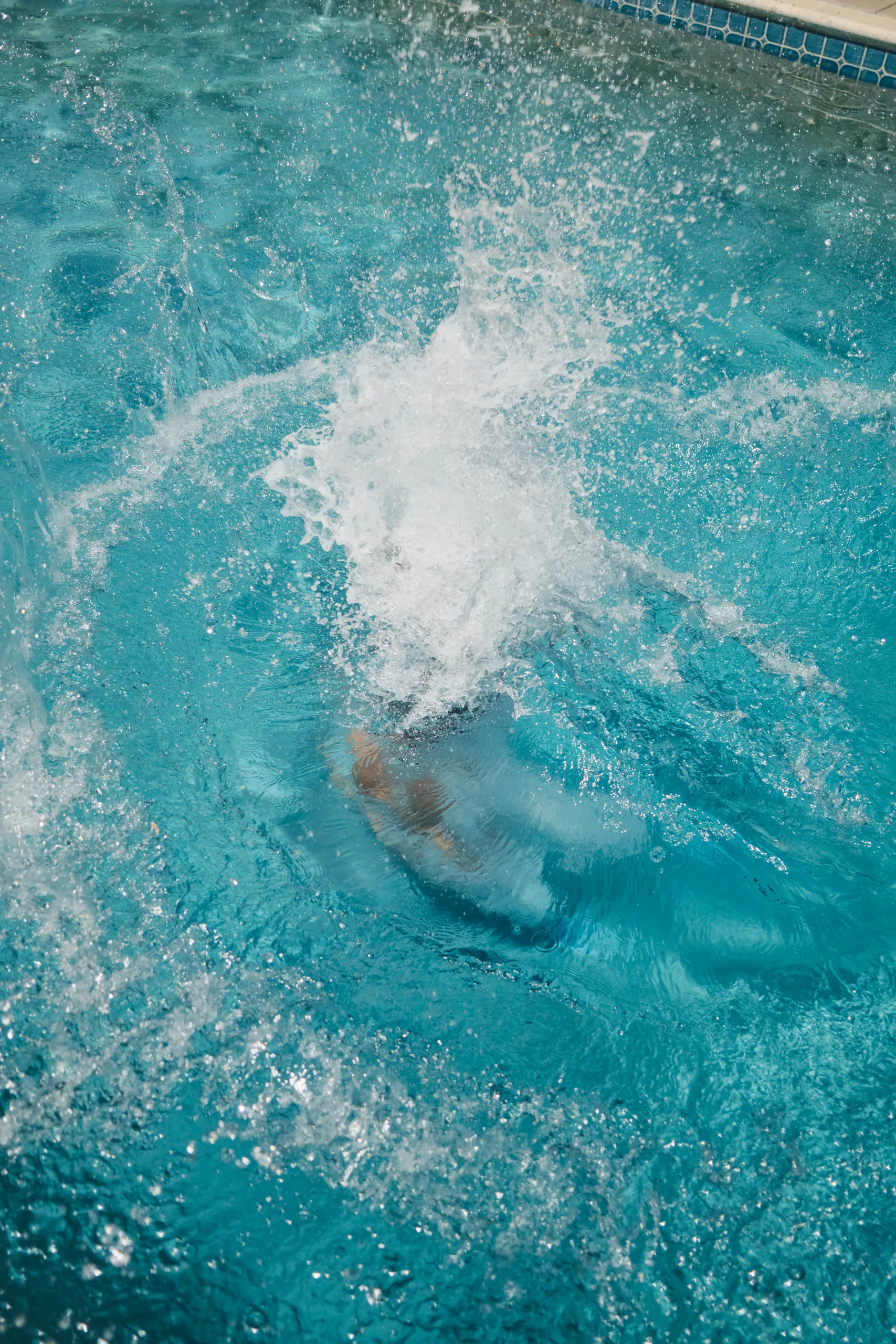 Swimmer making a big splash in the turquoise saltwater pool