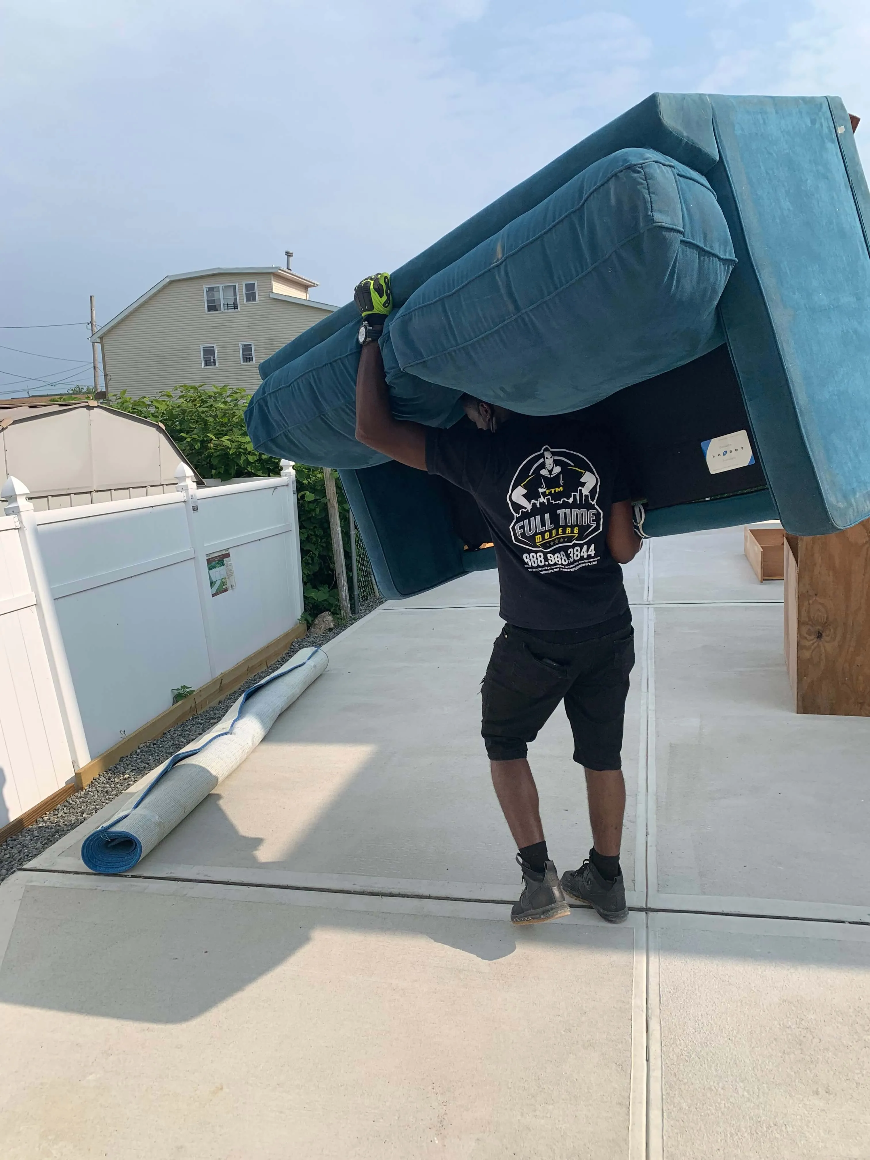 Two Full Time Movers Labor Professionals standing in a truck packed with stacked moving boxes