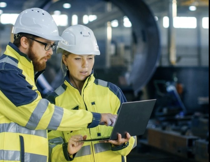 Engineers reviewing a laptop on a plant floor