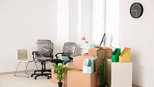 Office chairs and cardboard boxes stacked in an empty office
