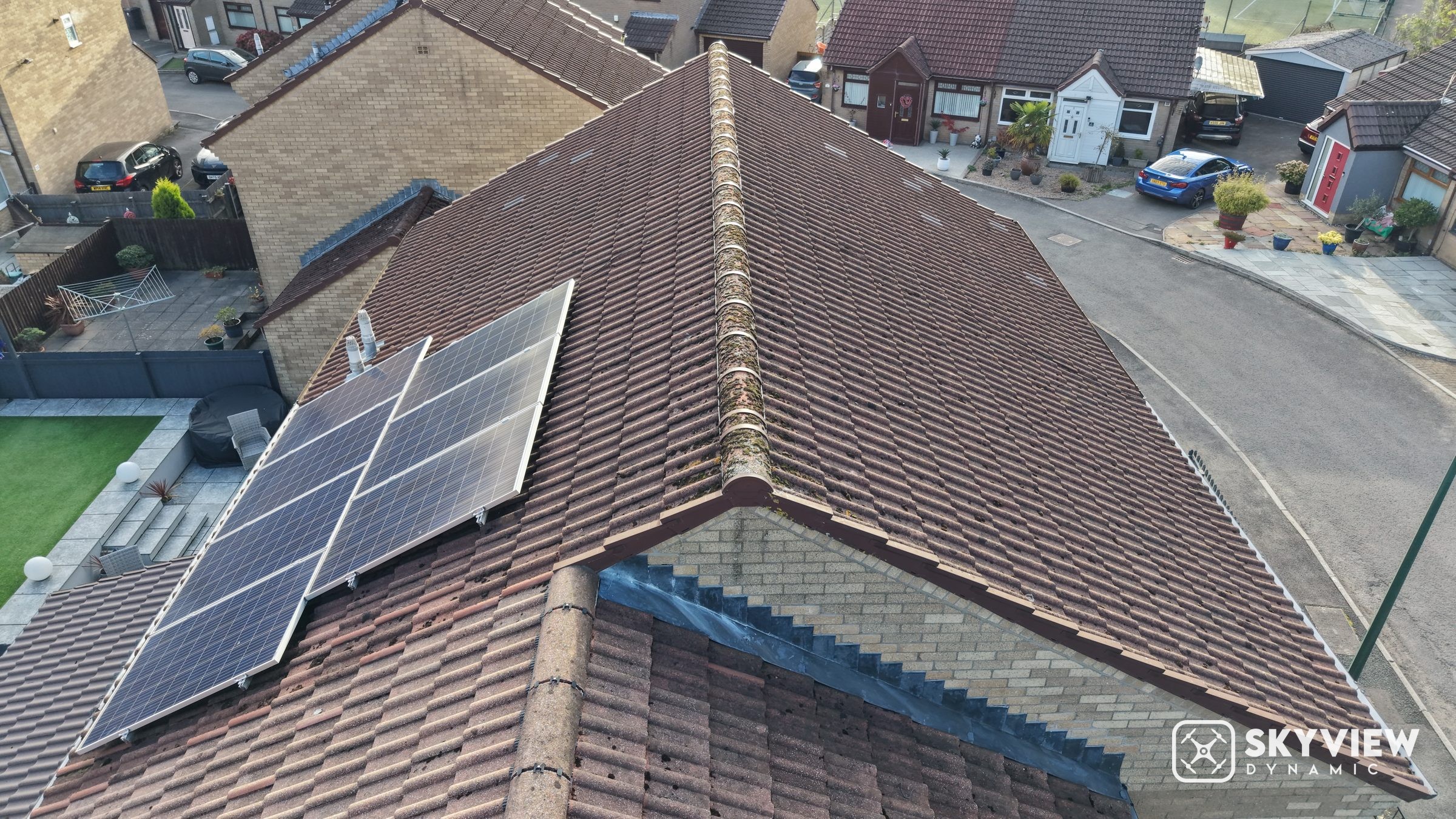 Drone view of a gable end and ridge, with solar panels on the neighbouring roof slope