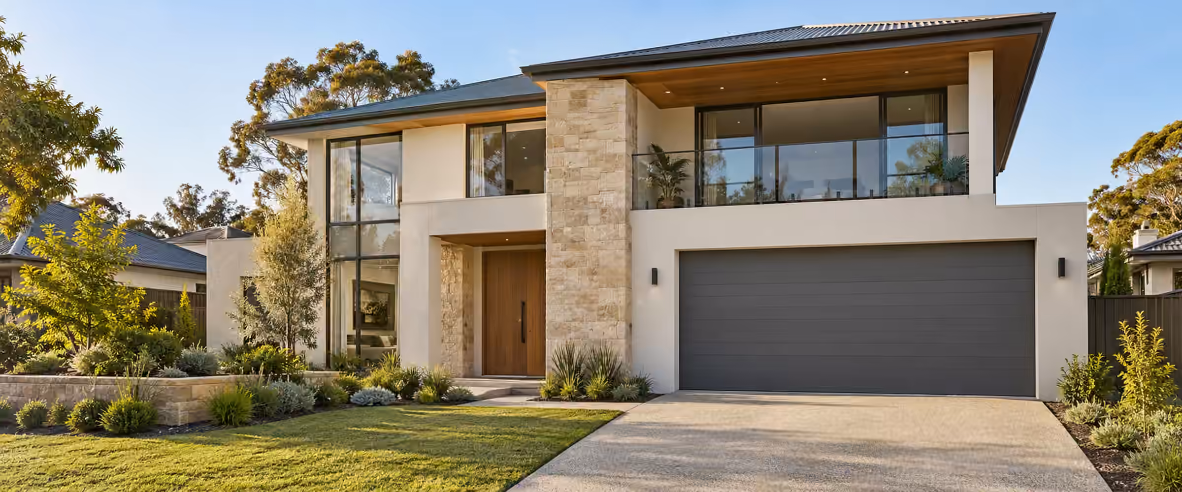 Completed two-storey home with a stone feature wall, charcoal garage door and new lawn
