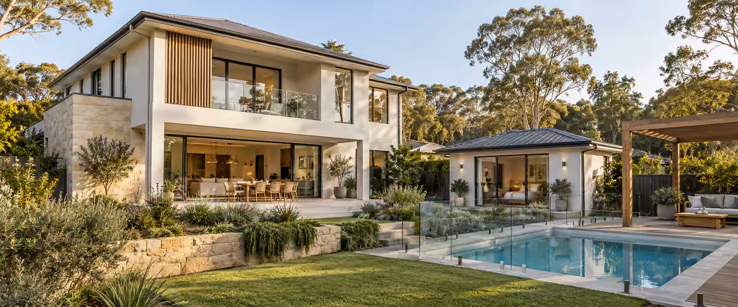 Two-storey rendered home with timber cladding, a glass pool fence, swimming pool and pergola