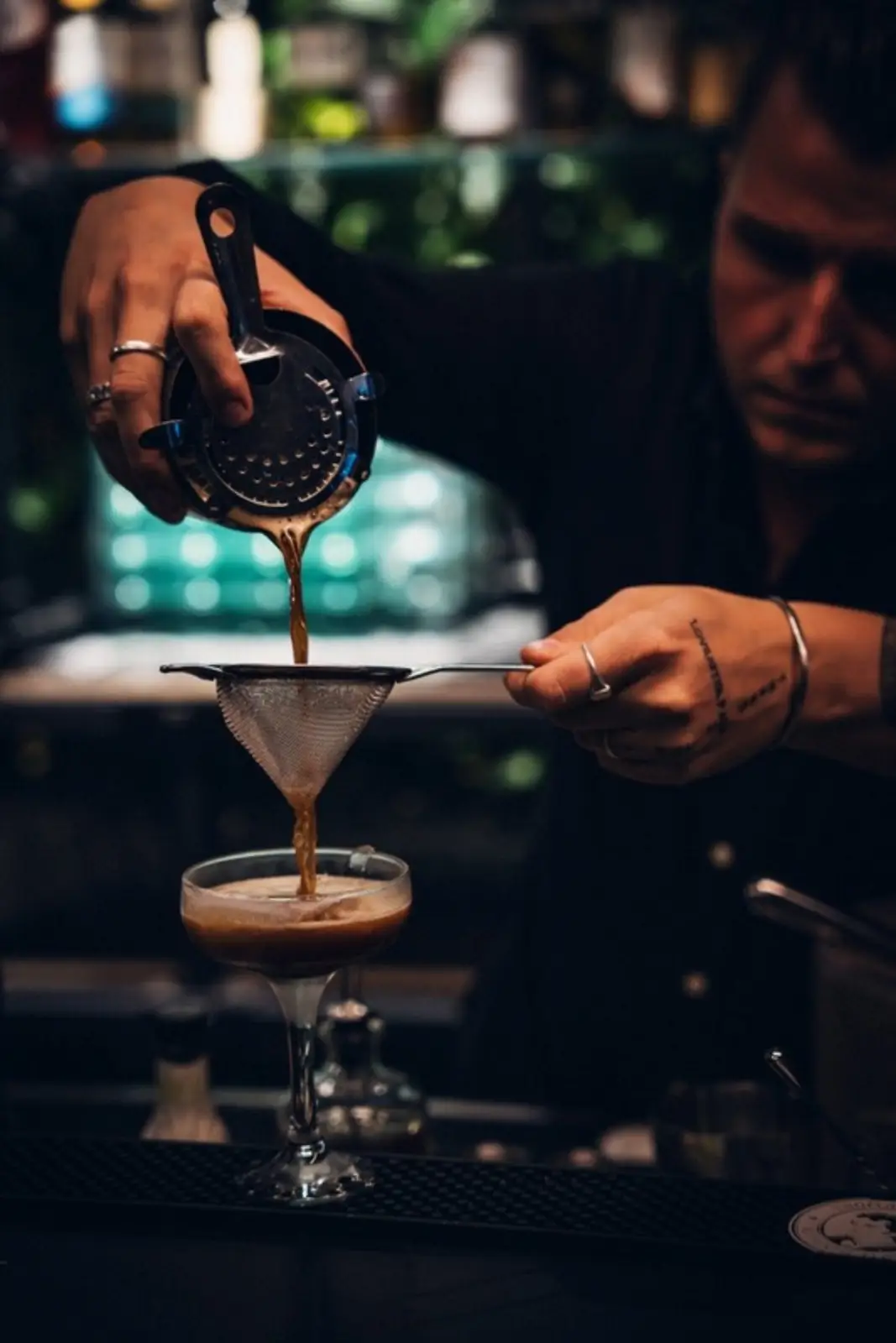 Barkeeper beim Abseihen eines Cocktails