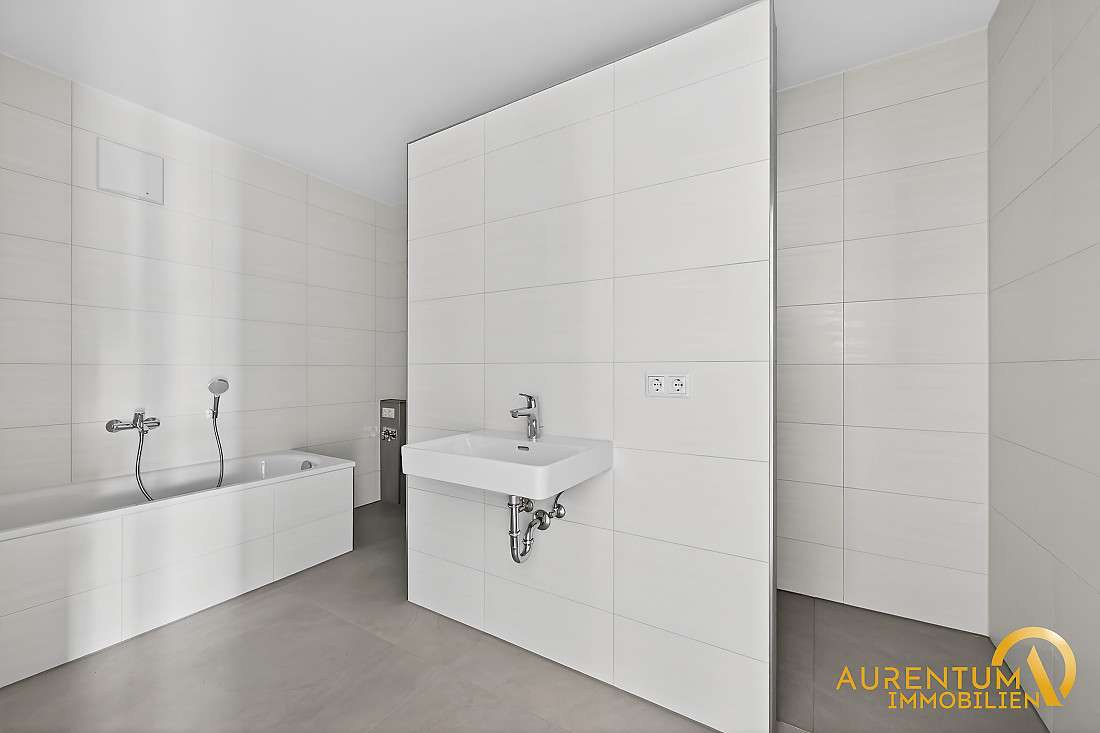 Badezimmer einer Referenzwohnung mit Badewanne und bodengleicher Dusche