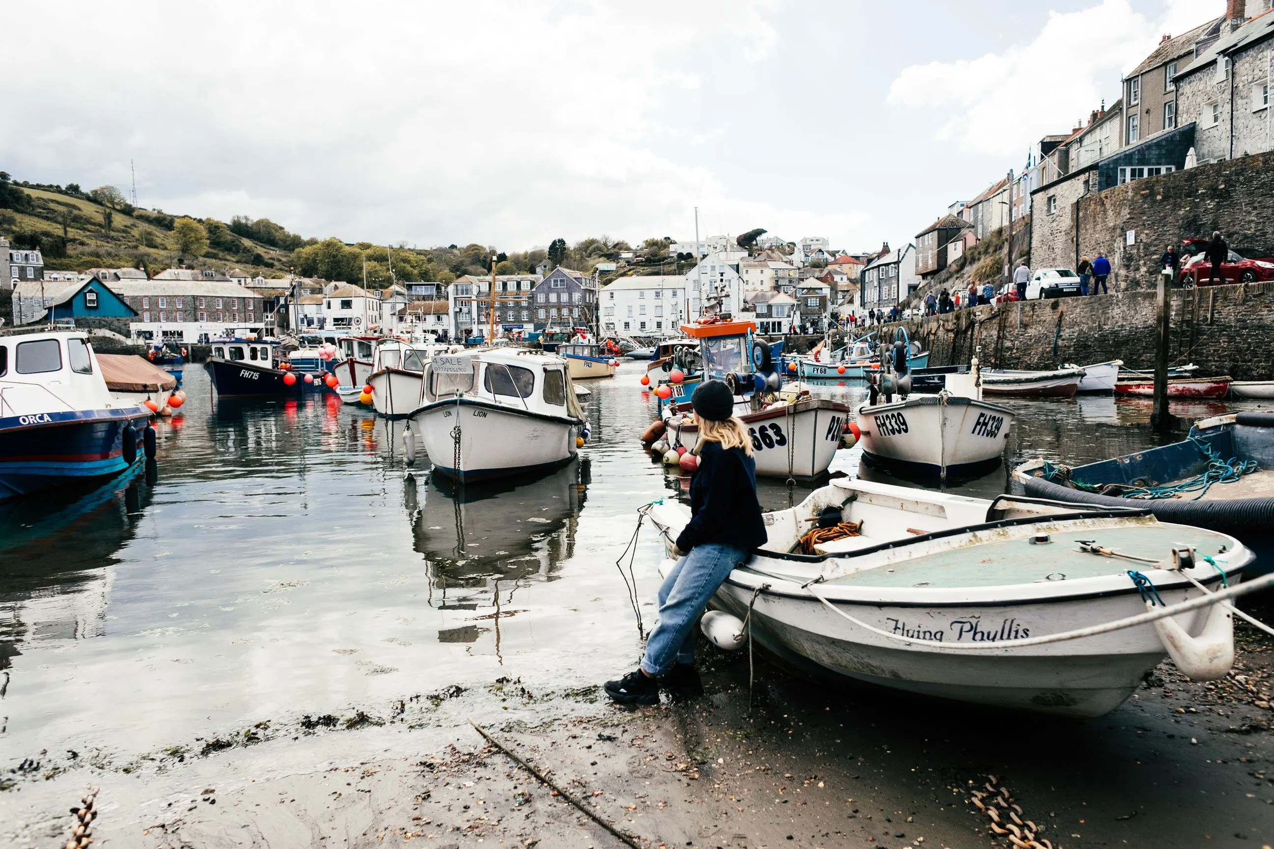 Cornish fishing harbour with moored boats and stone-built houses
