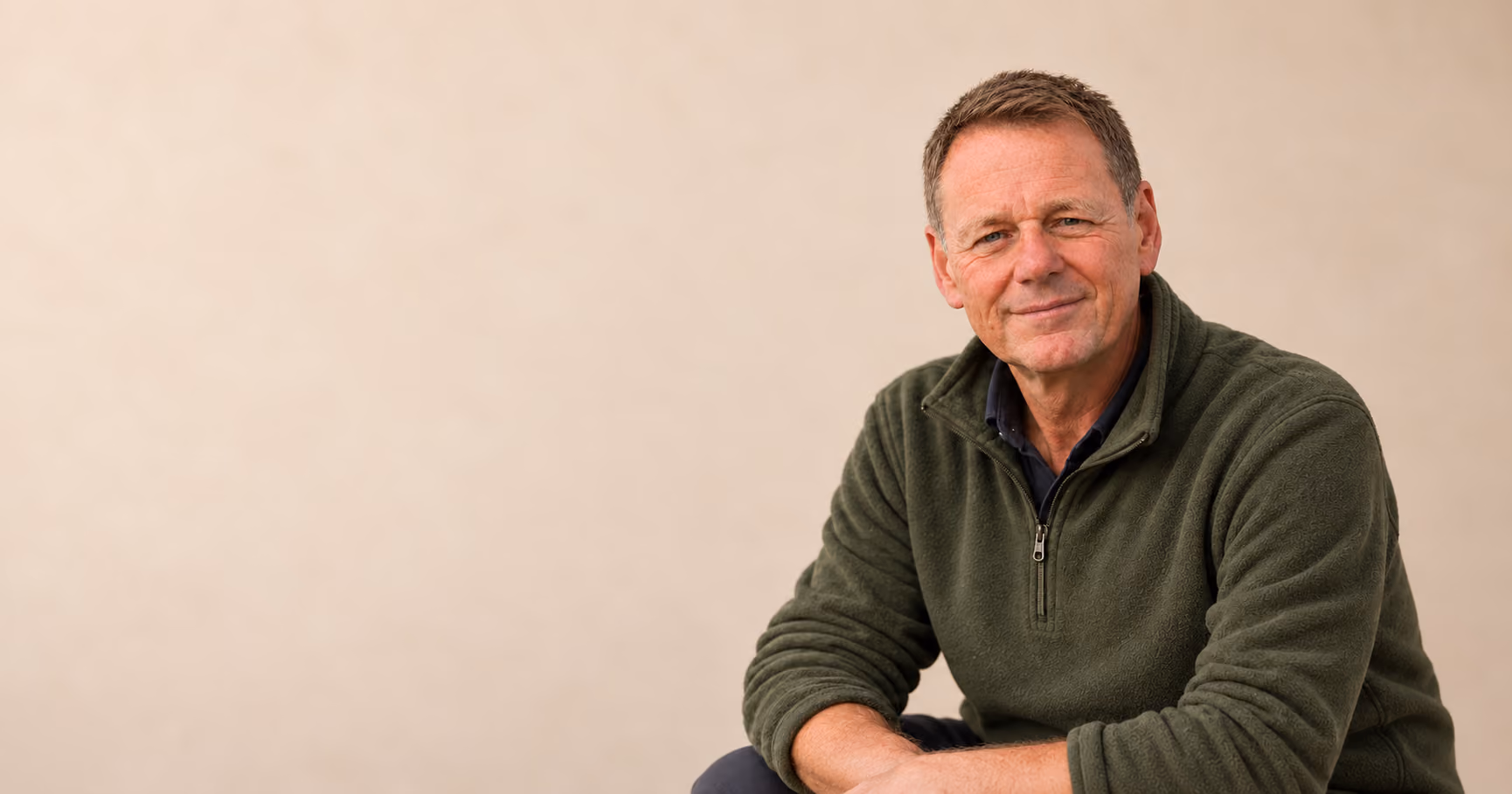 Michael, smiling, in an olive-green fleece