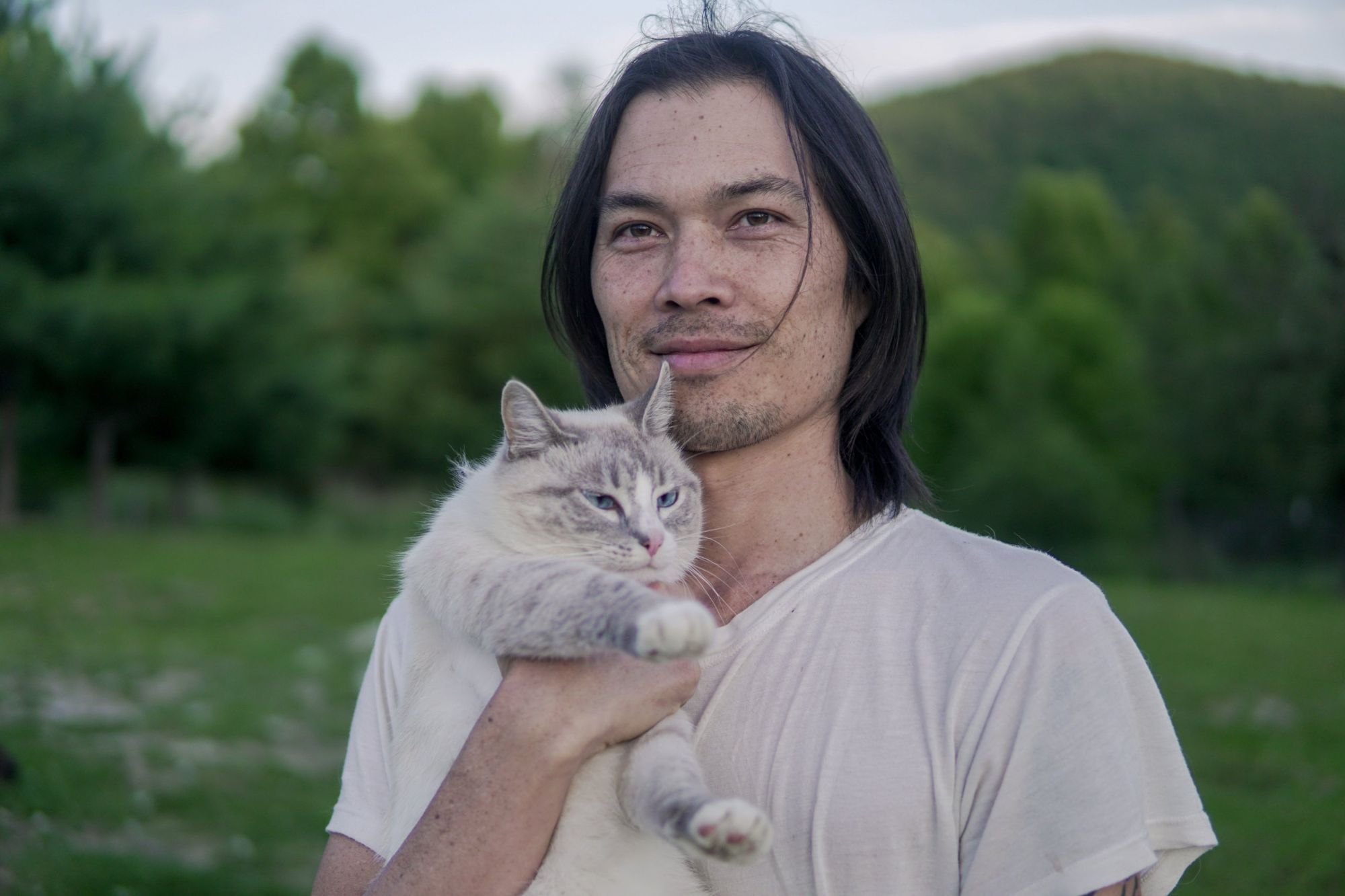 Gene Eu holding a cat on his former US farm